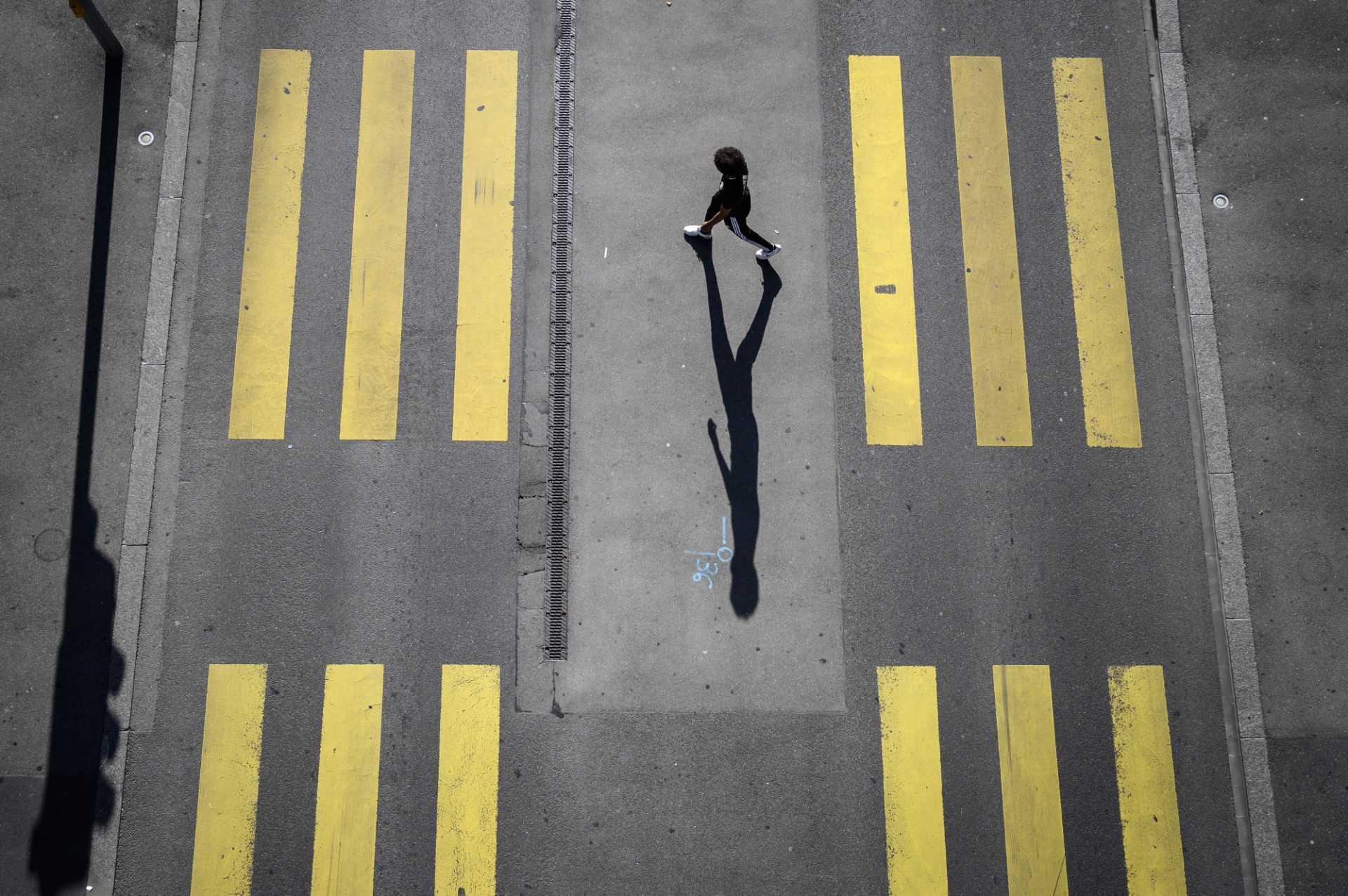 A pedestrian walks on a pedestrian crossing in Lausanne, Switzerland, on Aug 18, 2020. Photo: AFP