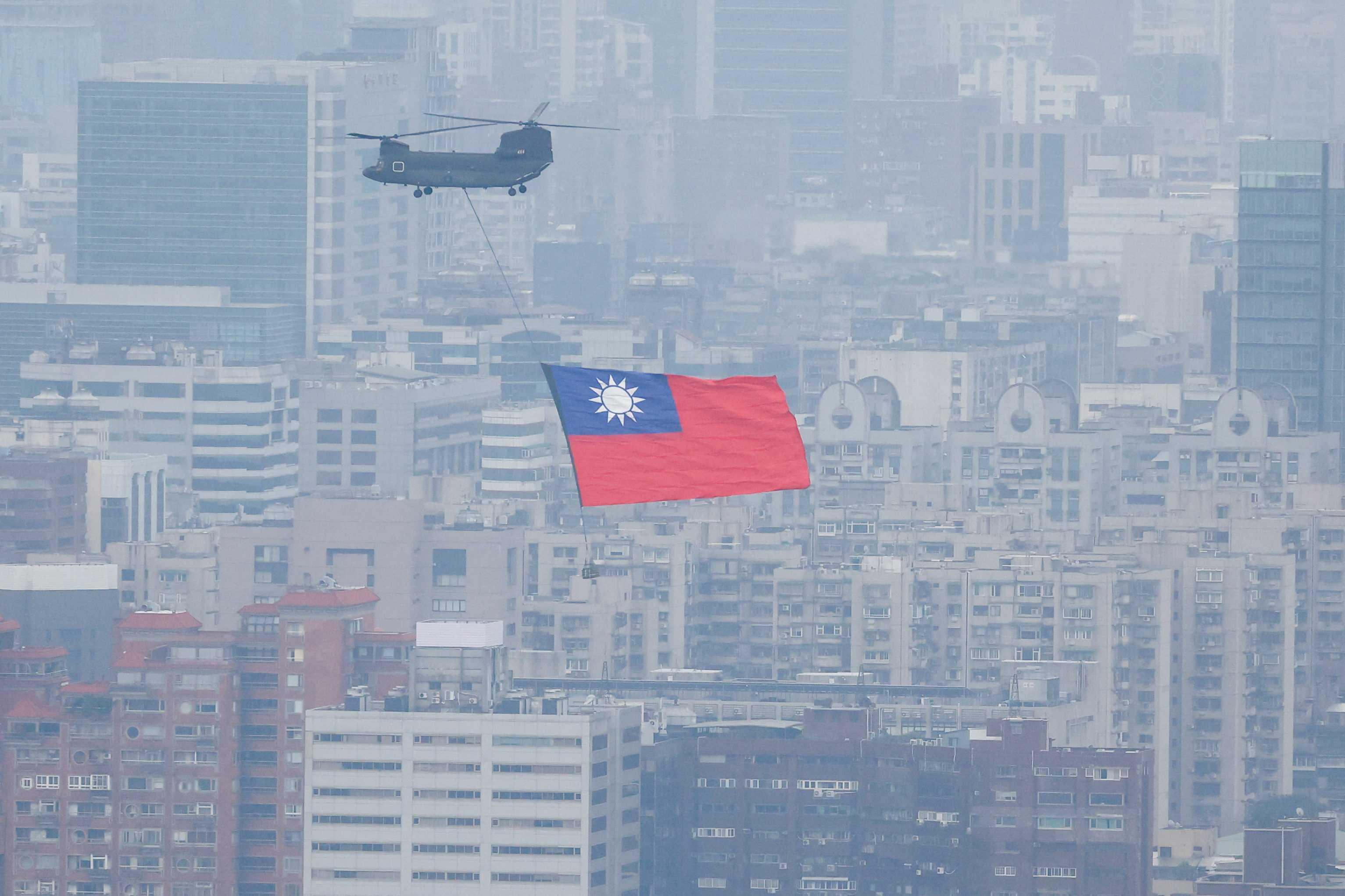 A Chinook helicopter carrying a Taiwan flag flies over the city during the country's National Day celebration in Taipei, Taiwan Oct 10. Photo: Reuters