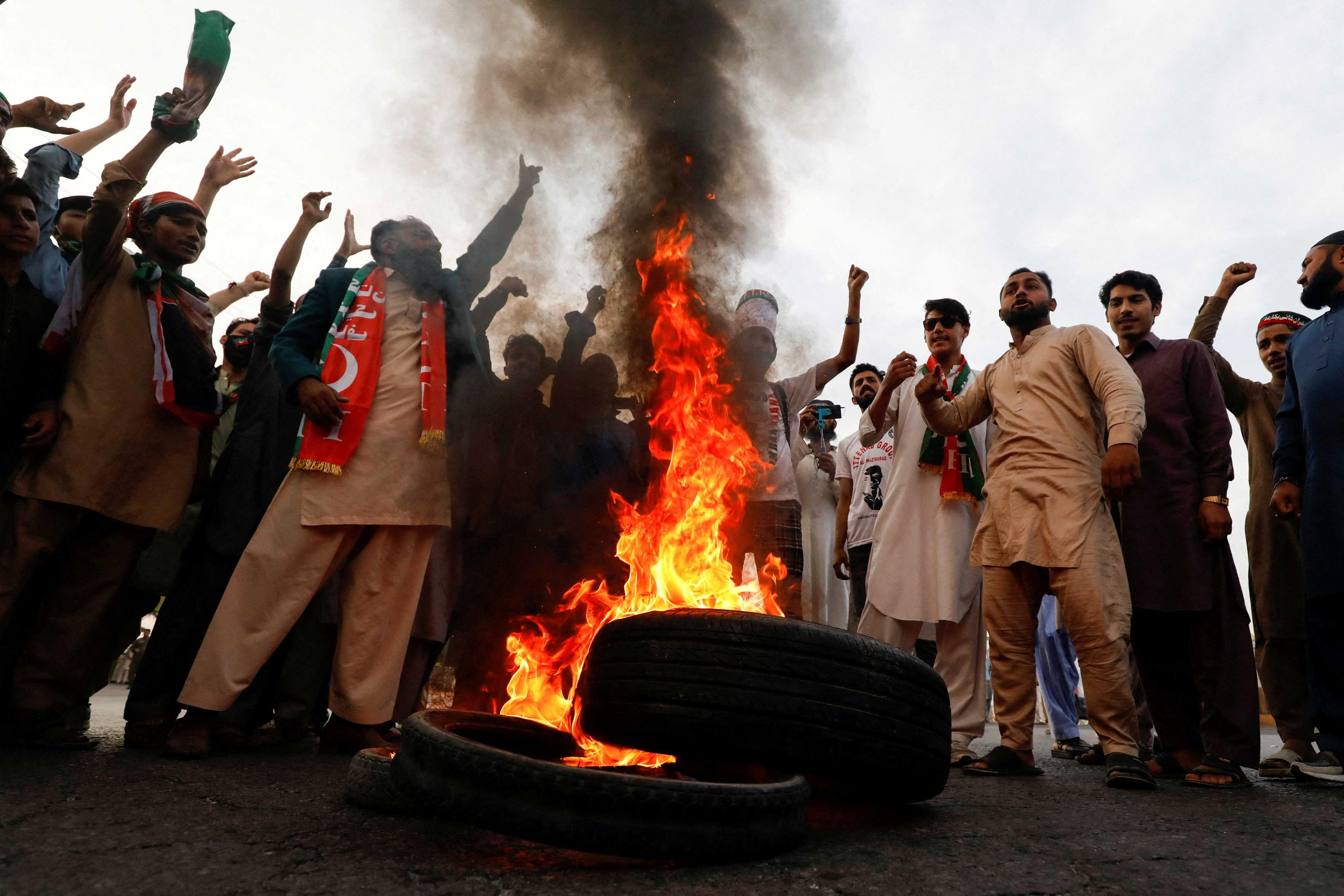 People chant slogans as they burn tires to block main highway during a protest to condemn the shooting incident on a long march held by Pakistan's former Prime Minister Imran Khan, in Wazirabad, Pakistan Nov 4. Photo: Reuters