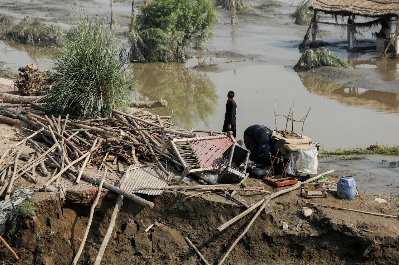 A man stands at the site of his damaged house, following rain and floods during the monsoon season, in Nowshera, Pakistan, Aug 31. Photo: Reuters