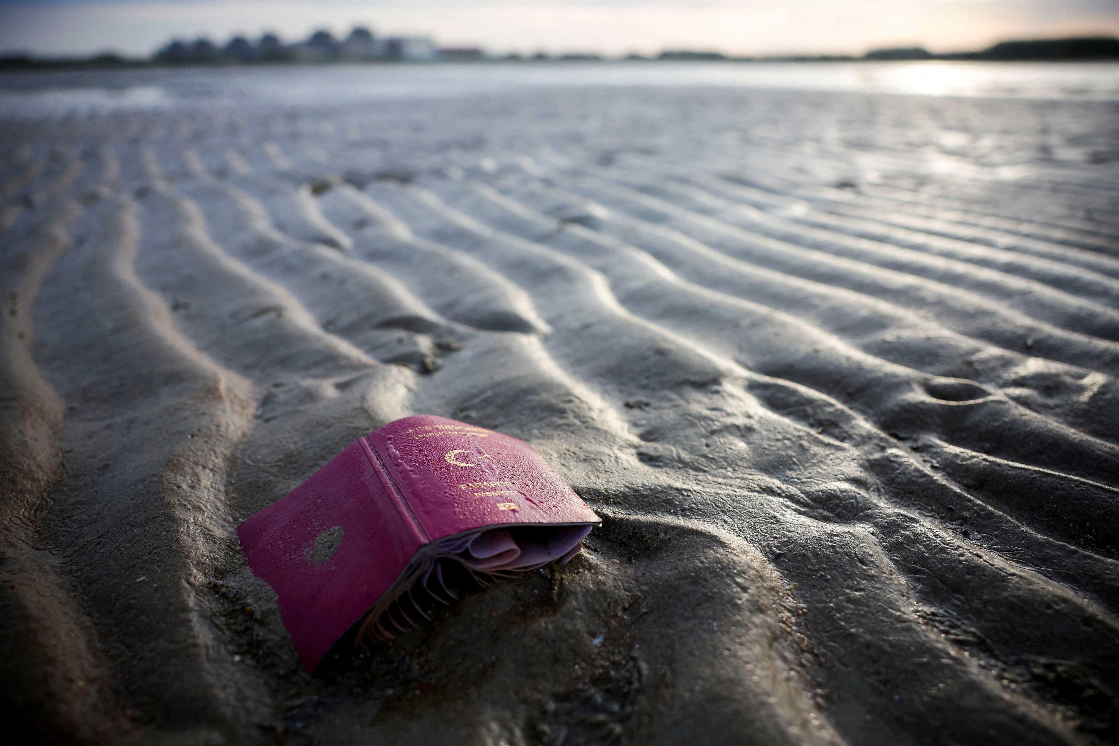 A passport is seen on the beach after a group of migrants traveled on an inflatable dinghy to leave the coast of northern France and to cross the English Channel, in Gravelines near Calais, northern France, Oct 30. Photo: Reuters