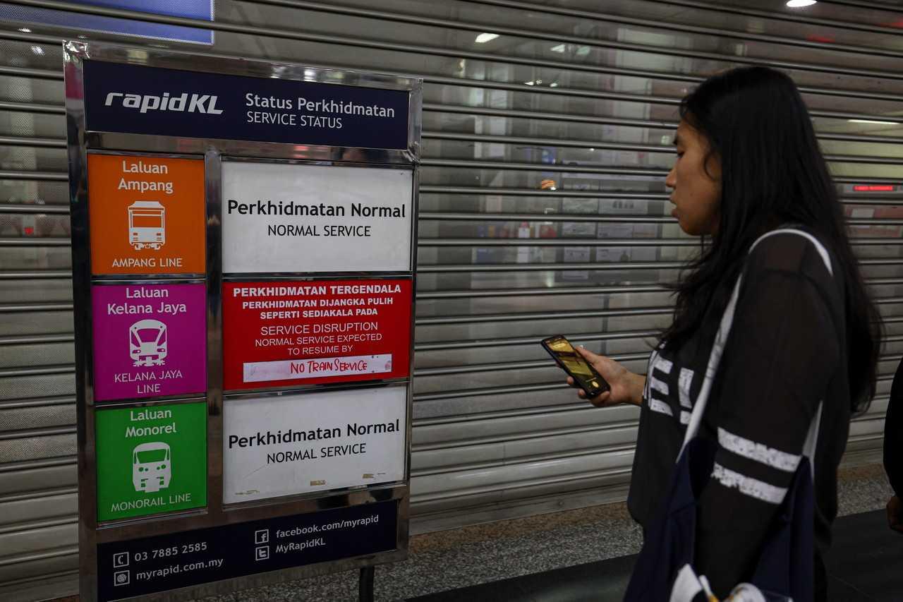 A commuter looks at the service status board showing disruptions at the KL Sentral station in Kuala Lumpur. Photo: Bernama