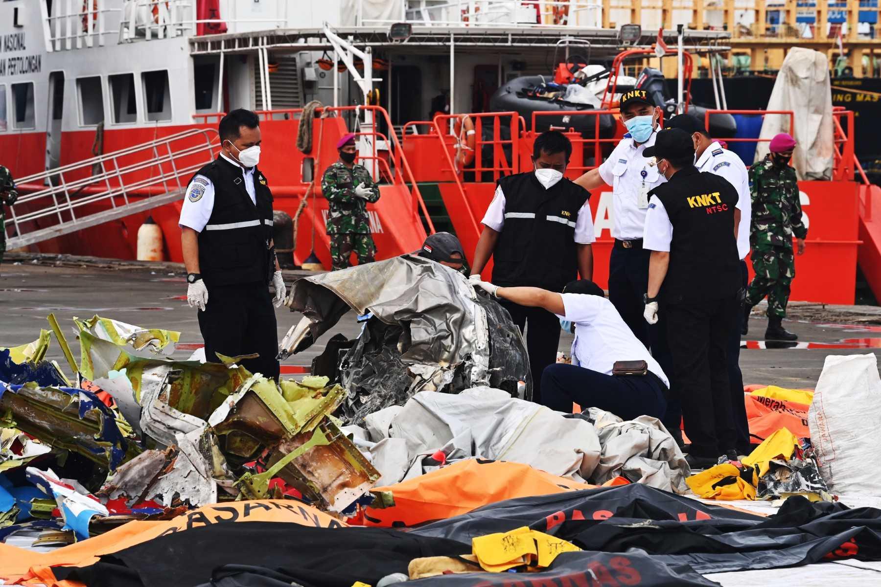Members of the National Transportation Safety Committee examine the turbine of Sriwijaya Air flight SJ182 at Tanjung Priok port, north of Jakarta on Jan 13, 2021, found during search operations for the plane which crashed into the sea minutes after take-off on Jan 9. Photo: AFP