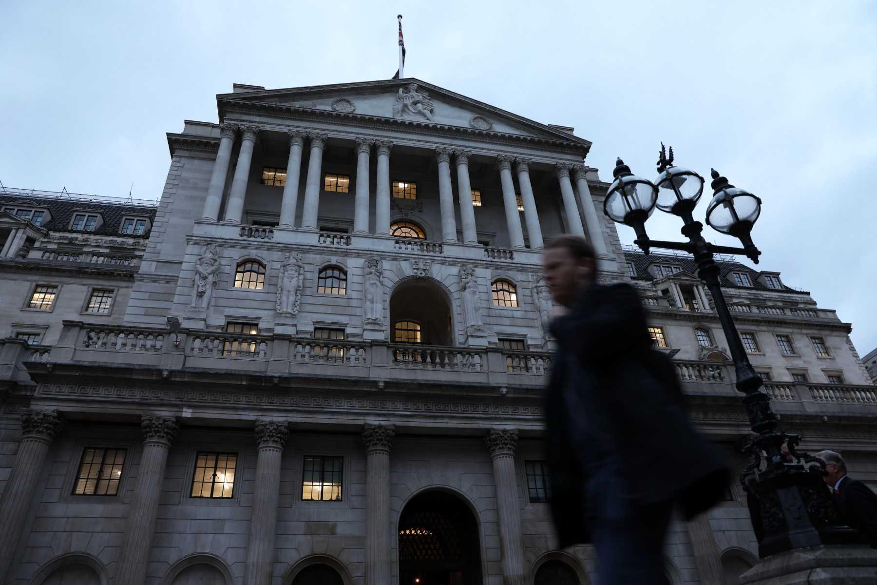 Seorang lelaki berjalan di hadapan Bank Pusat Britain di London. Gambar: AFP