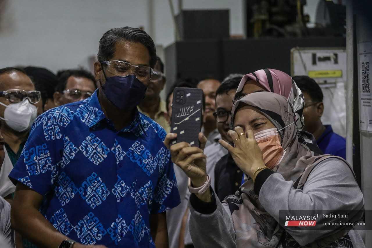 Barisan National's Sungai Buloh candidate, Khairy Jamaluddin, takes a selfie with a worker during a visit to SME Aerospace in Sungai Buloh, yesterday.   
