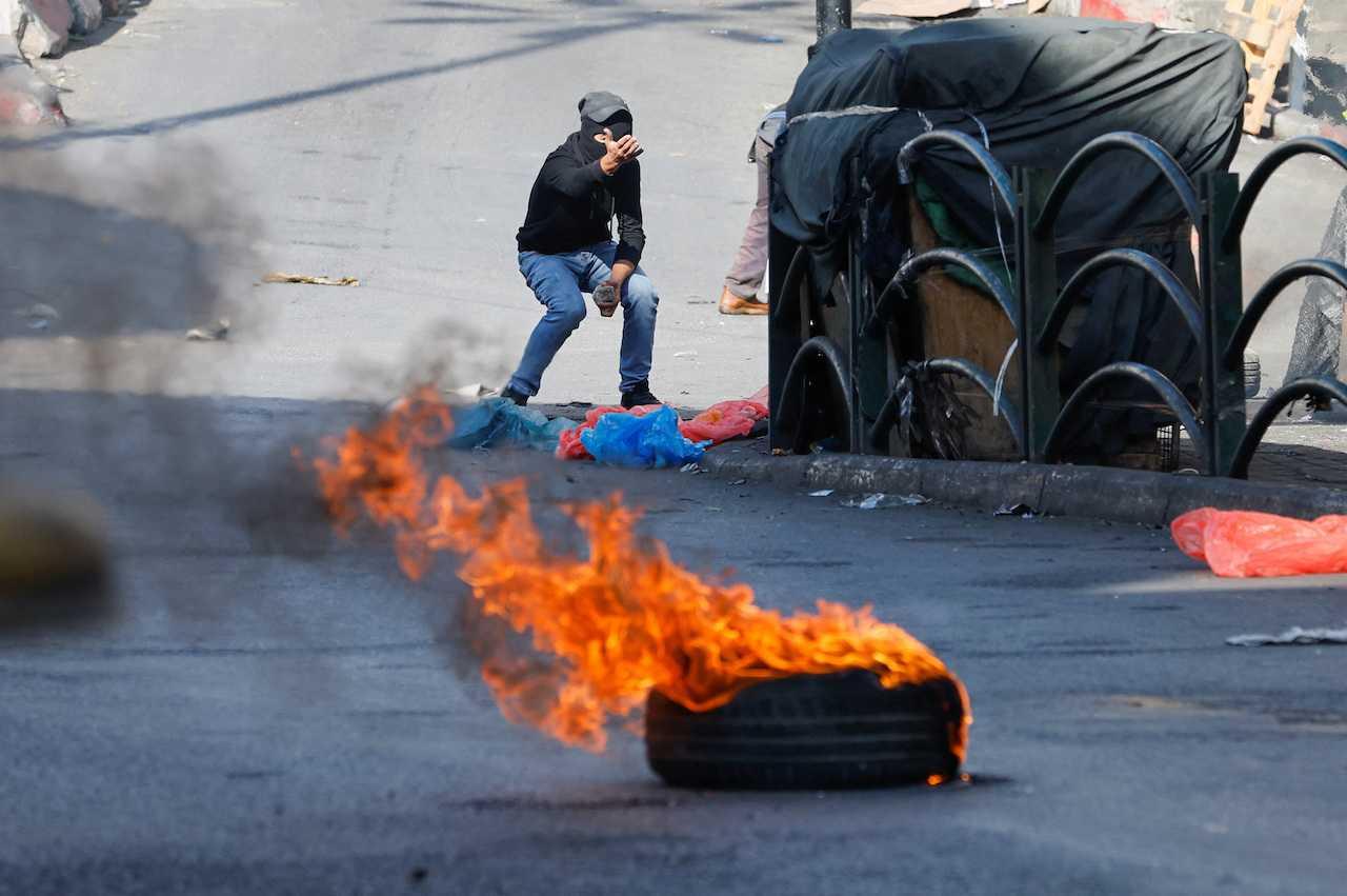 A man holds a stone, as Palestinians clash with Israeli forces during a protest in Hebron, in the Israeli-occupied West Bank, Nov 4. Photo: Reuters