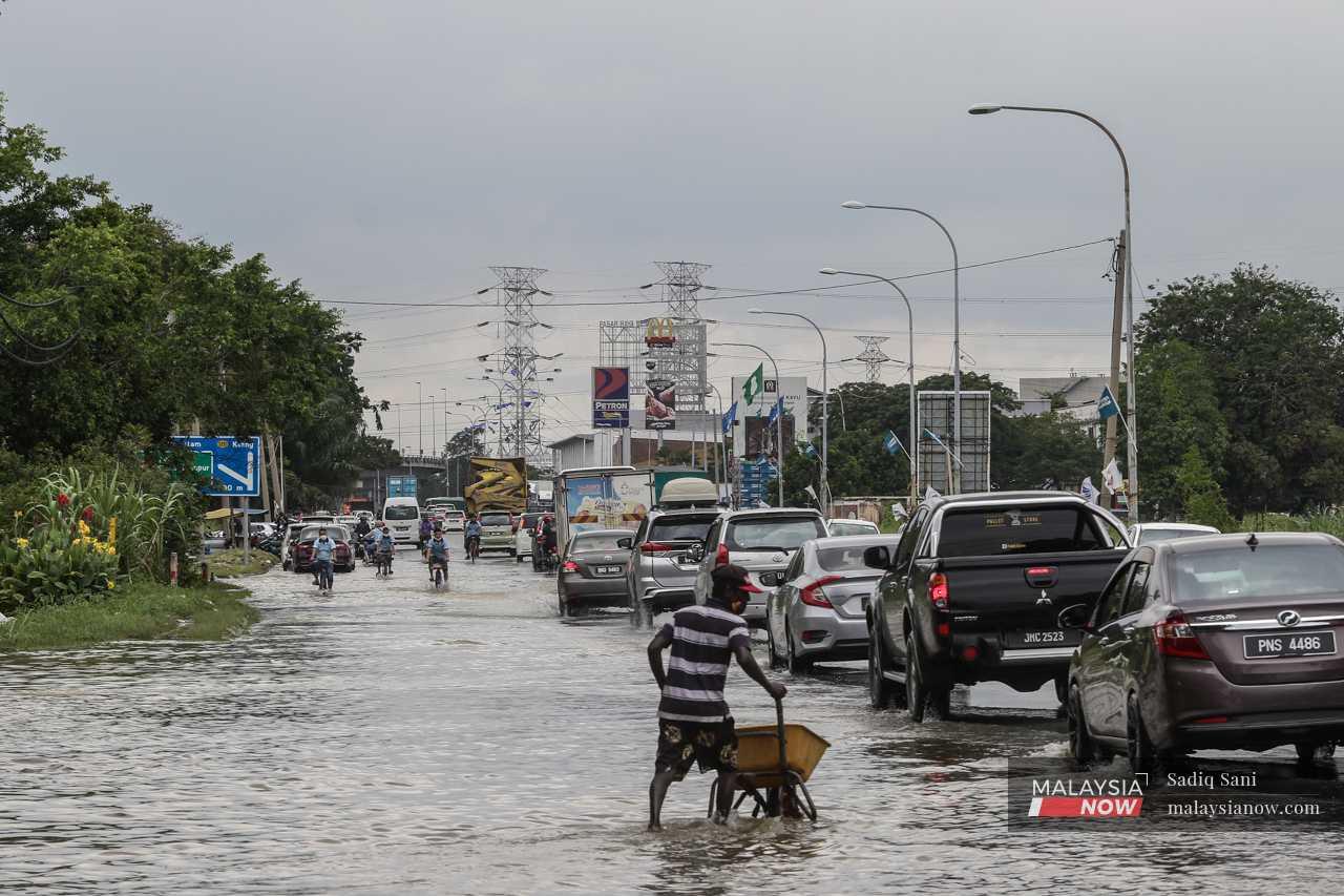 Di jalan raya, banjir menyebabkan kesesakan lalu lintas kerana kenderaan terpaksa bergerak perlahan.