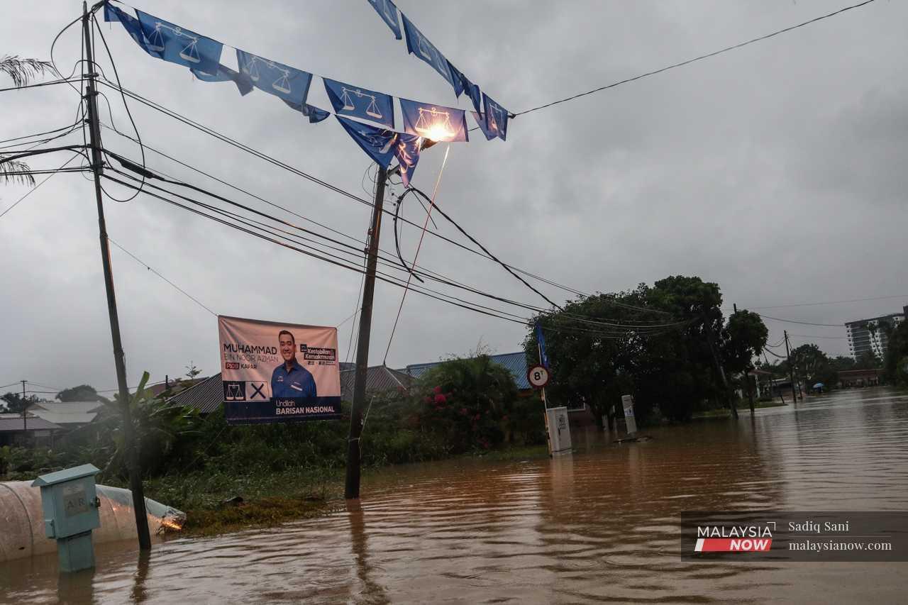Suasana senja di Jalan Paip yang mengalami banjir, di mana bendera parti politik yang digantung di kawasan sekitarnya basah akibat hujan berpanjangan.