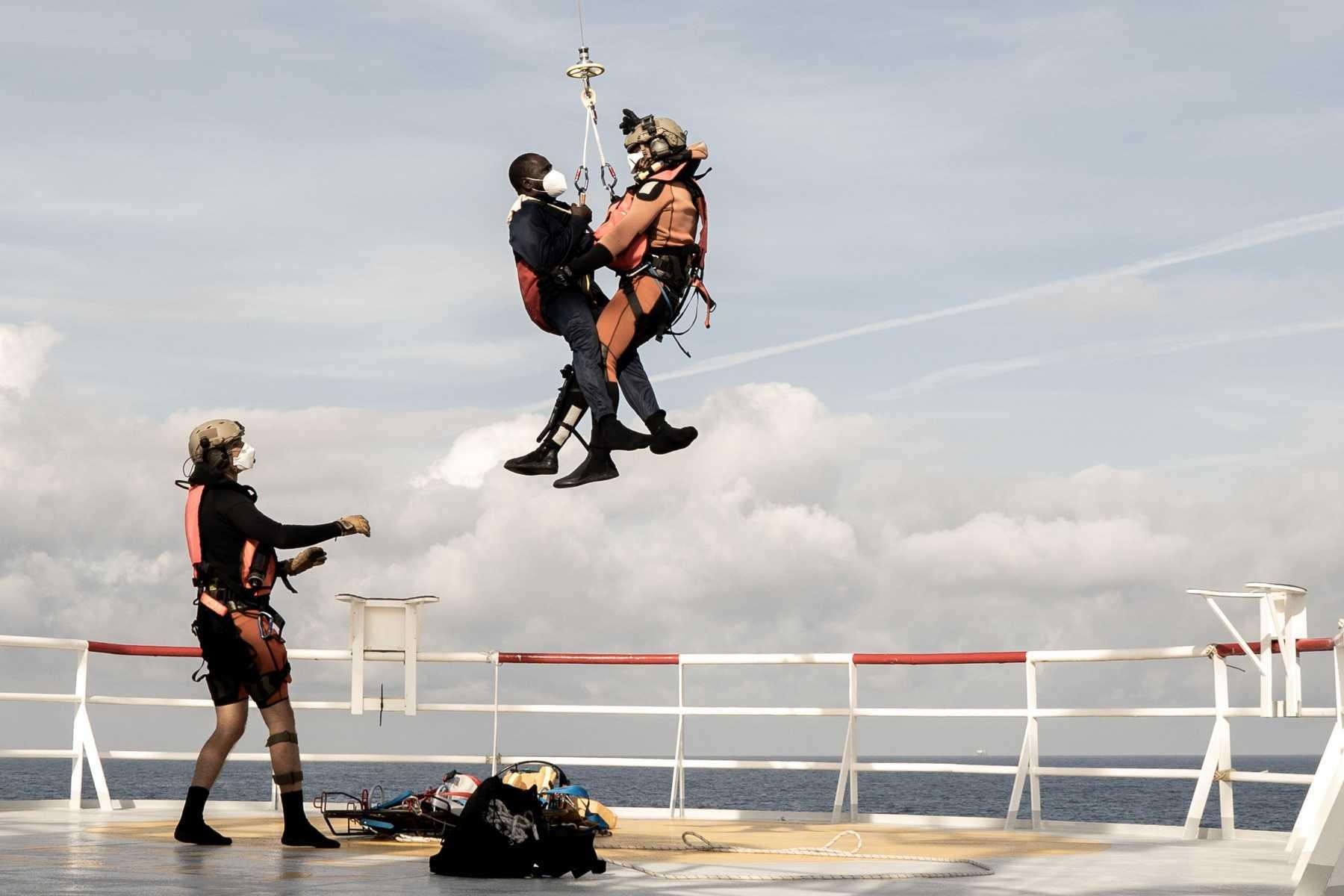 A migrant in need of urgent medical care (centre) is winched up by a helicopter of the French army from the Ocean Viking rescue ship on Nov 10, in the Tyrrhenian Sea between Italy and Corsica island. Photo: AFP