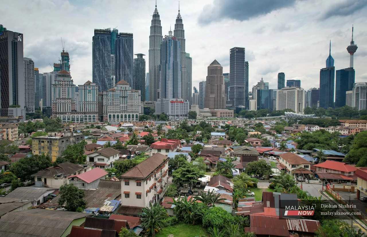 Bangunan pencakar langit Menara Kuala Lumpur dan Menara Berkember Petronas melatari kejiranan Melayu Kampung Baru di tengah Kuala Lumpur.