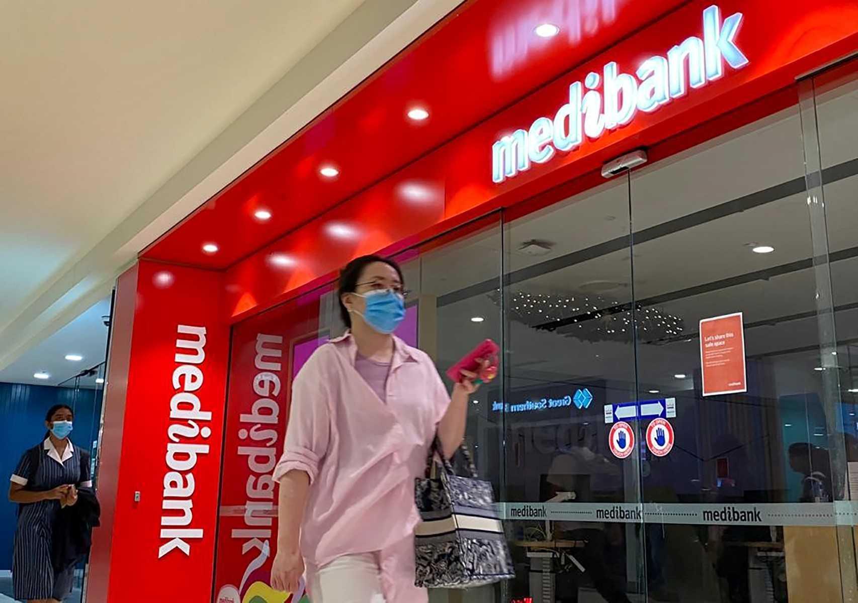 People walk past a shop front for Australia's largest health insurance company Medibank, in Sydney on Nov 11. Photo: AFP