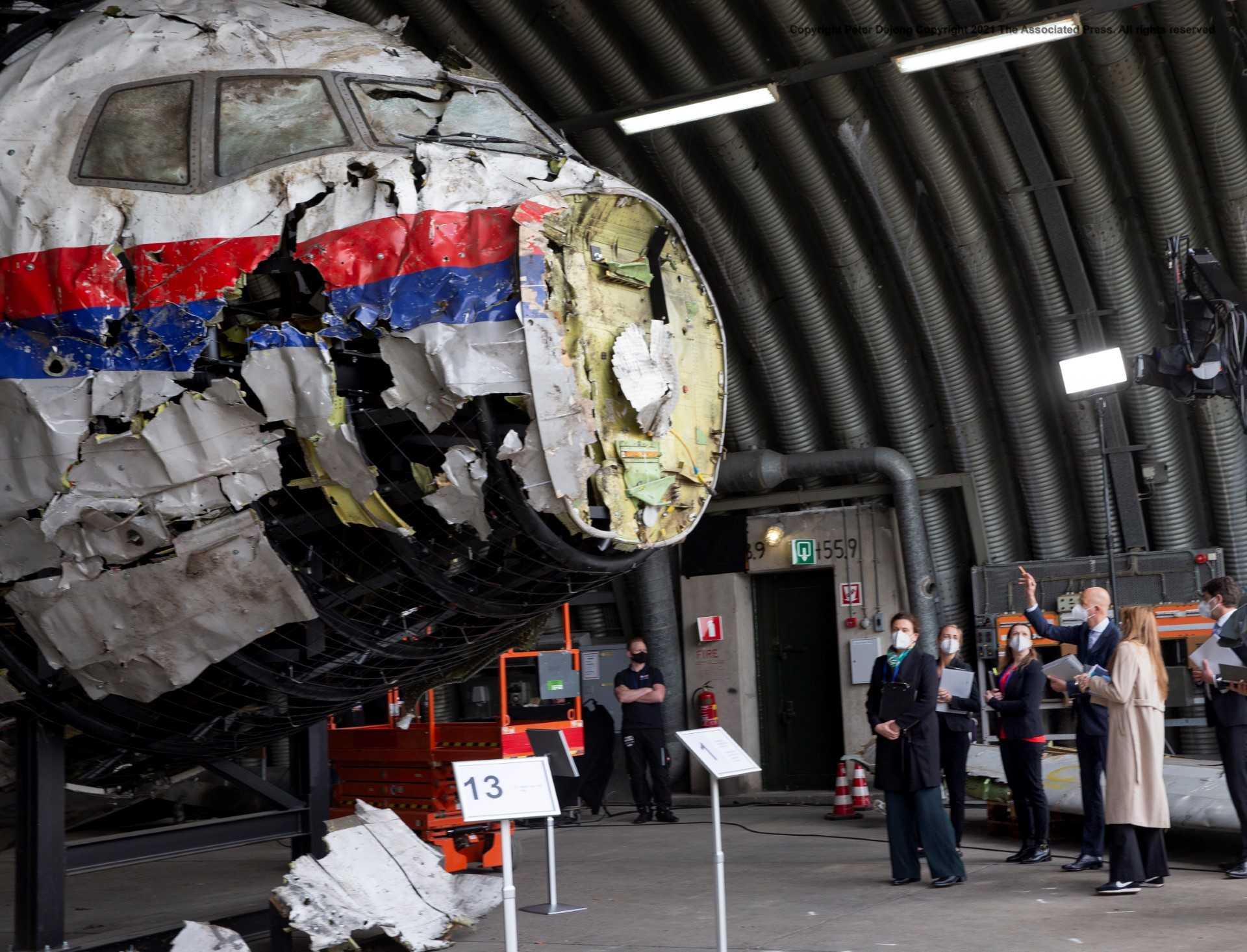 Presiding judge Hendrik Steenhuis (right) points as he and other trial judges and lawyers view the reconstructed wreckage of Malaysia Airlines flight MH17, at the Gilze-Rijen military airbase, southern Netherlands, on May 26, 2021. Photo: AFP