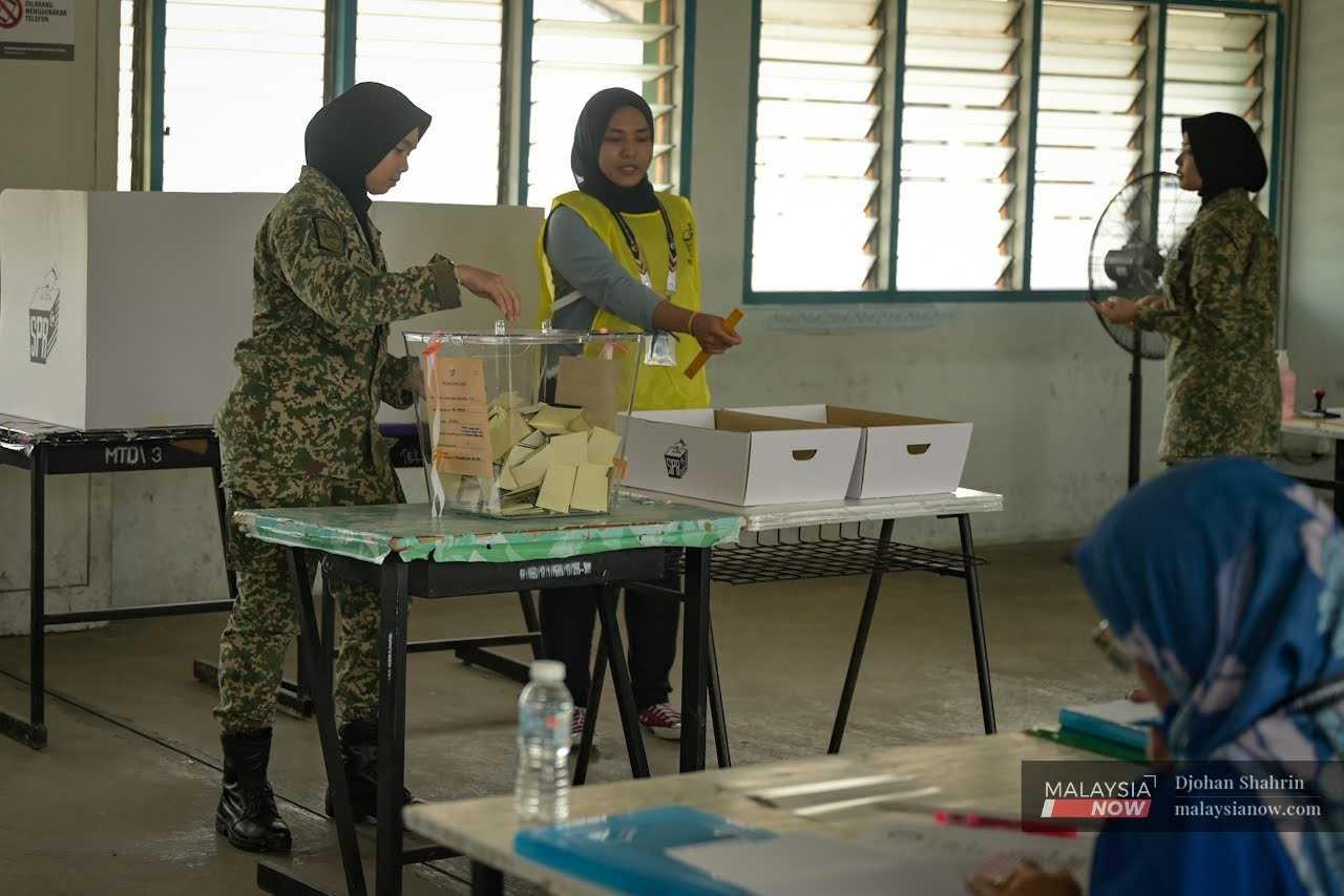 A member of the armed forces casts her ballot at the Sungai Besi camp in Kuala Lumpur during early voting today. 