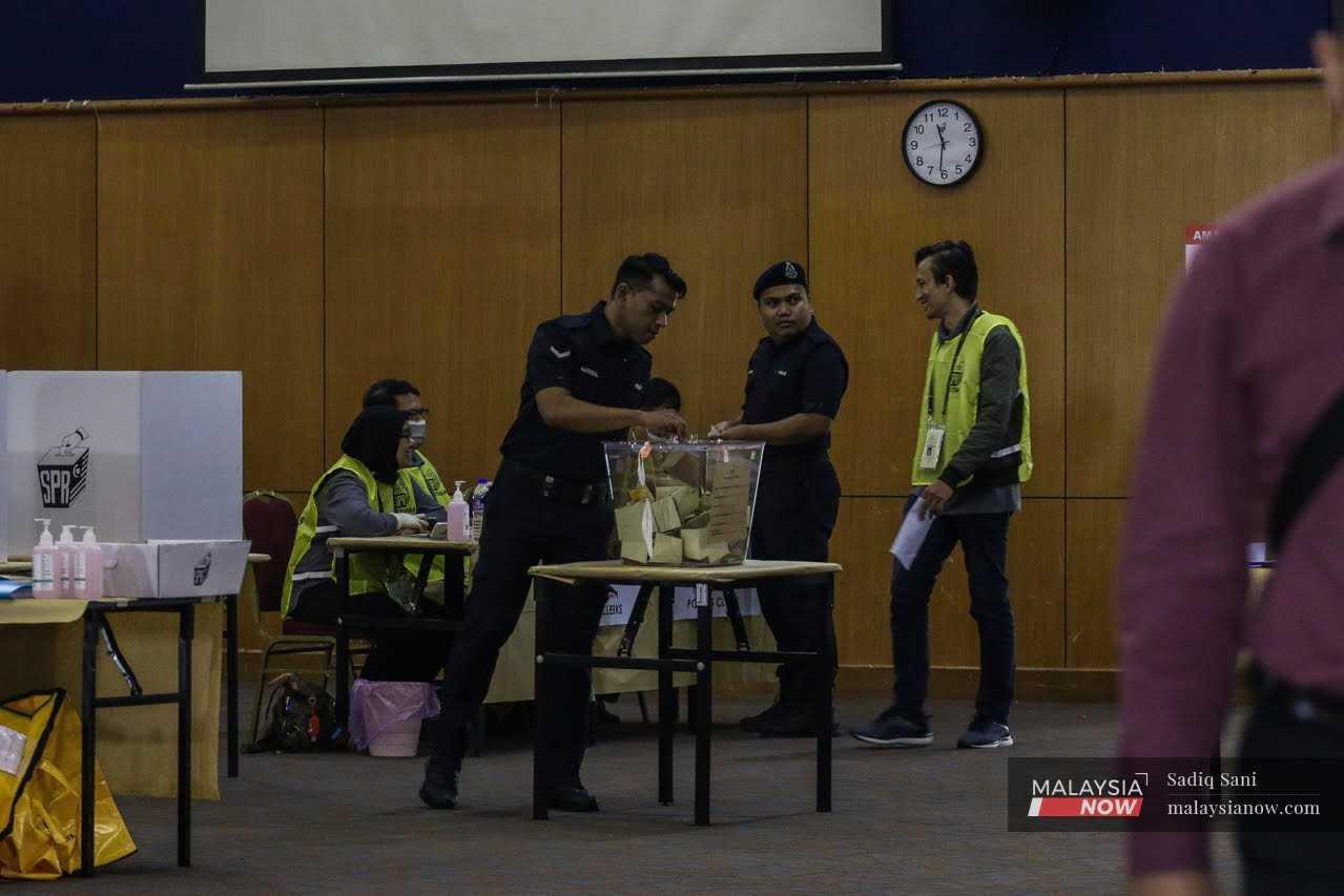 Anggota polis membuang undi di pusat pengundian awal di Shah Alam, Selangor.