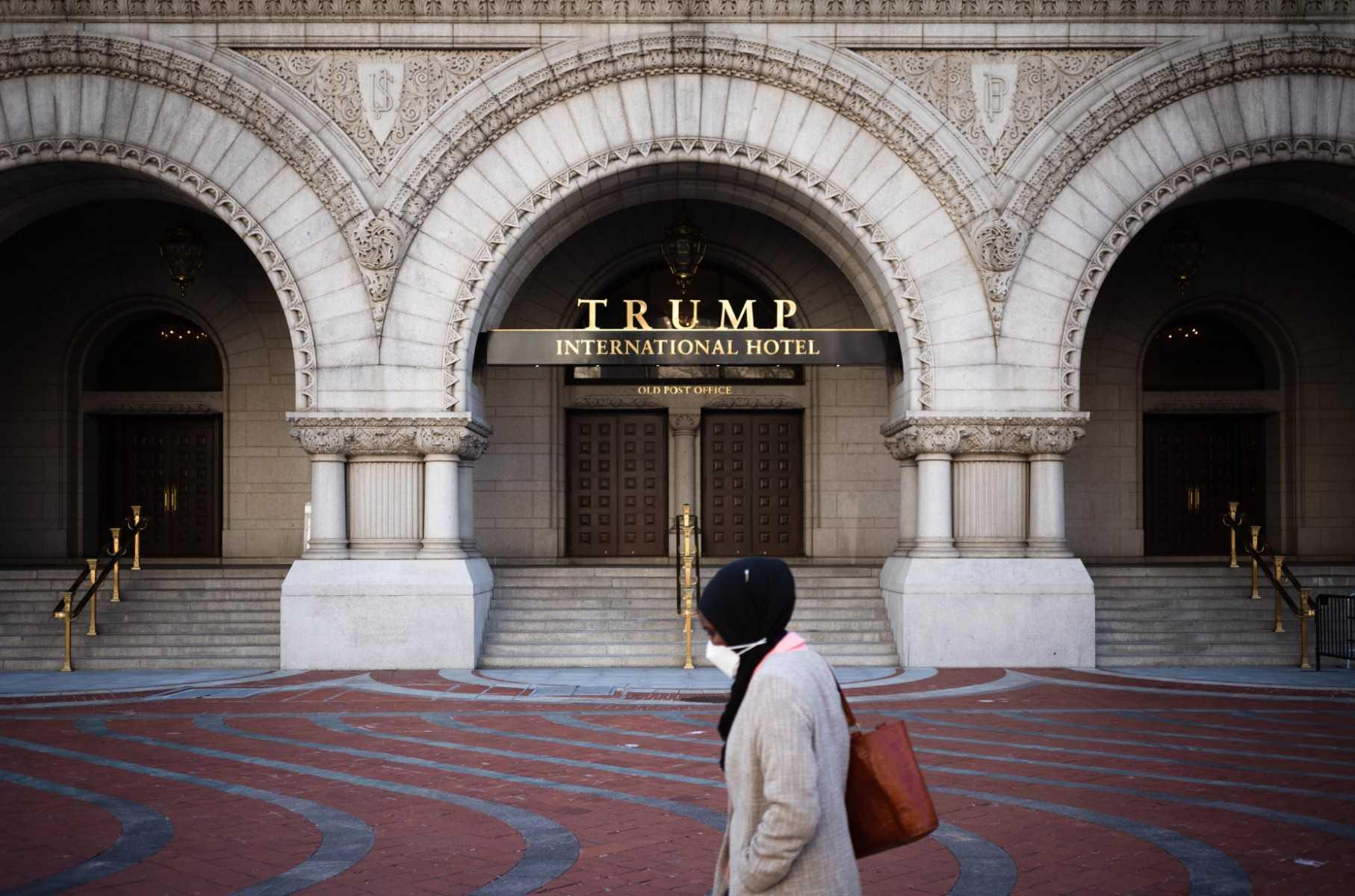 Seorang wanita berjalan di hadapan Hotel Antarabangsa Trump di Washington, AS. Gambar: AFP 