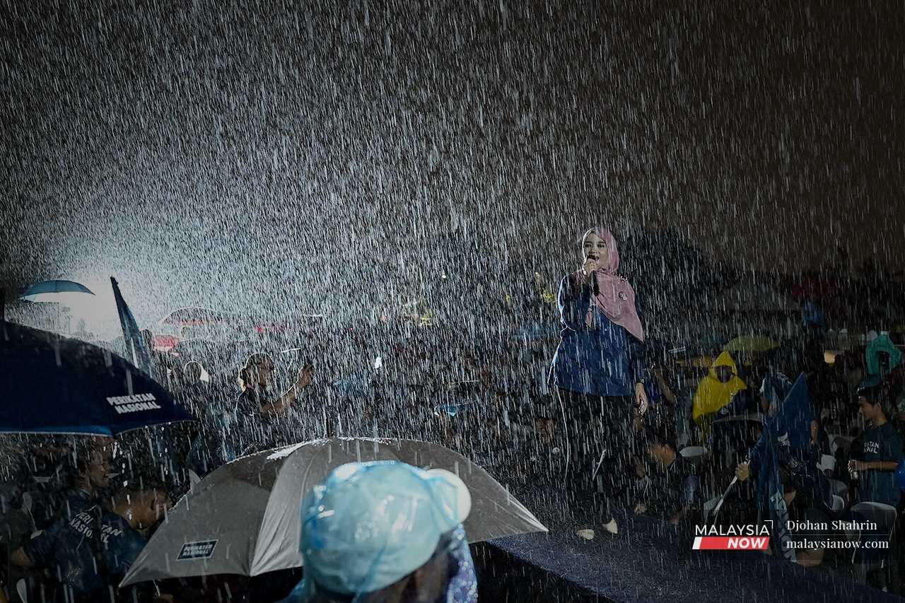 The rain grows steadily harder as Nurul Fadzilah speaks on stage. 
