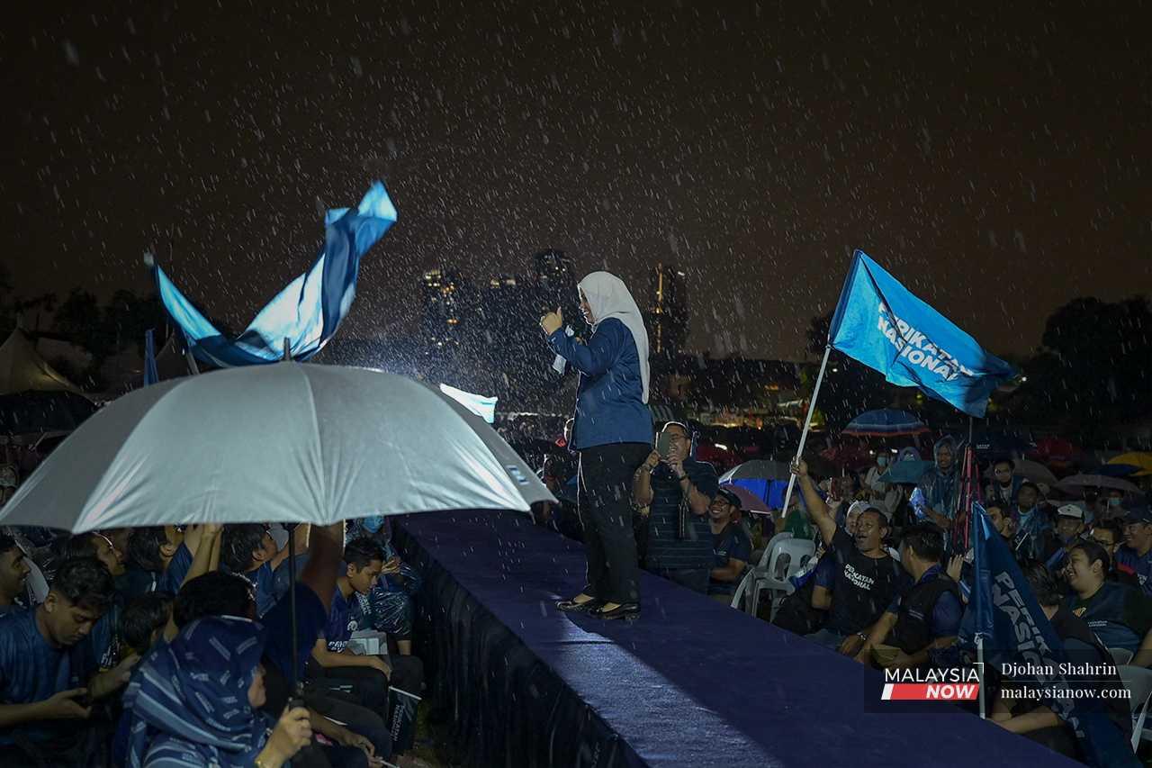 Perikatan Nasional's candidate in Ampang, Sasha Lyna, addresses the crowd in the rain at a gathering in Padang MPAJ Keramat AU2, Kuala Lumpur.