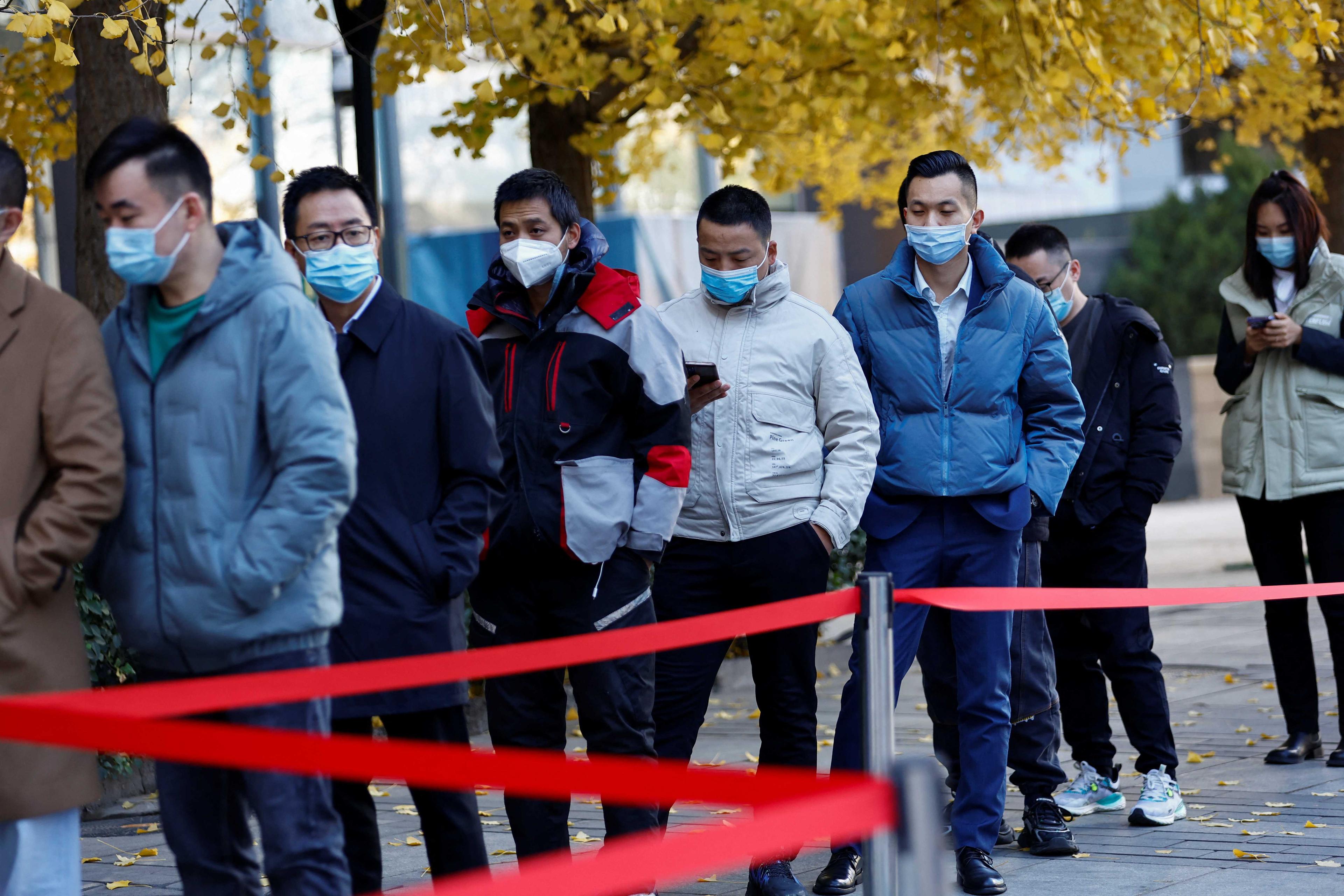 People line up to take a nucleic acid test for Covid-19 at a testing booth near an office building in Central Business District in Chaoyang district, Beijing, China Nov 15. Photo: Reuters