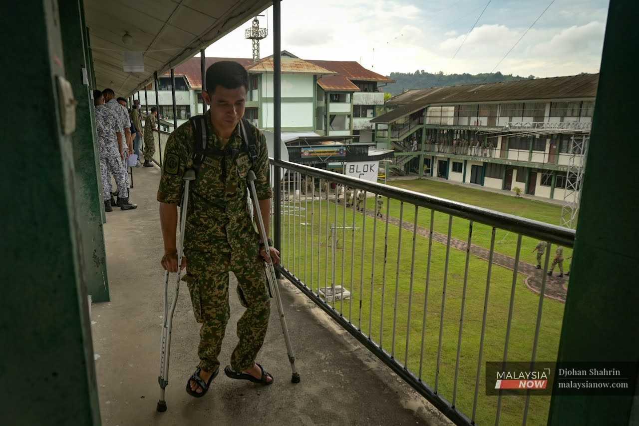 A serviceman leaves the polling room on crutches after casting his vote.