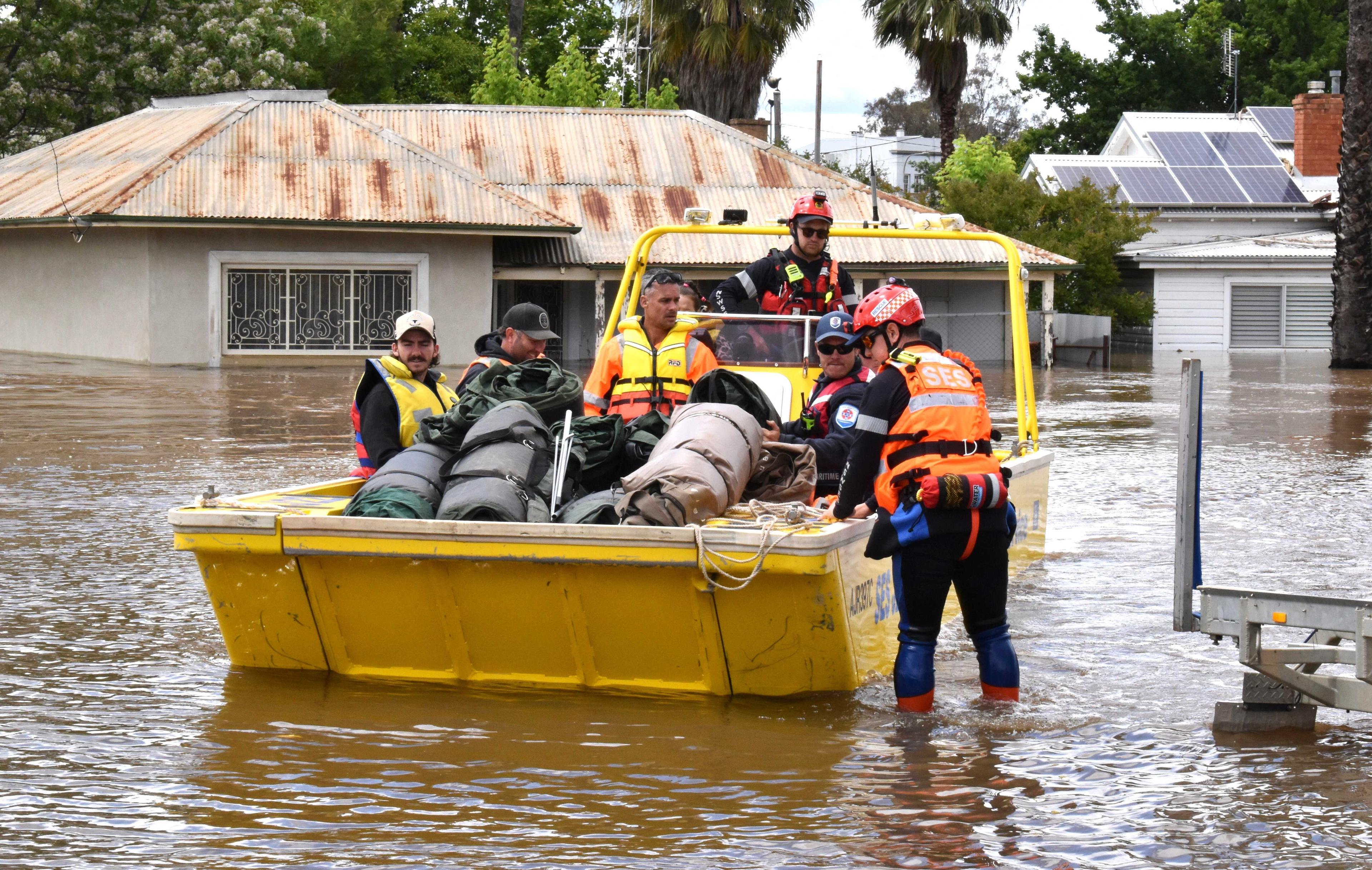 State Emergency Service personnel navigate floodwaters with residents and supplies aboard a watercraft at the town of Forbes, in the Central West region of New South Wales, Australia, Nov 16. Photo: Reuters