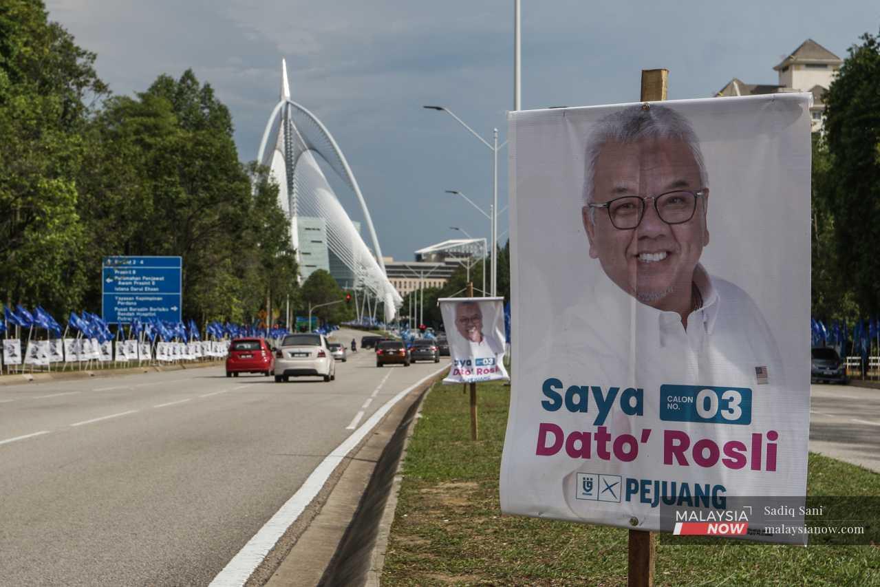 A poster of Pejuang's candidate, Mohd Rosli Ramli, hangs against the backdrop of the Seri Wawasan bridge. 

