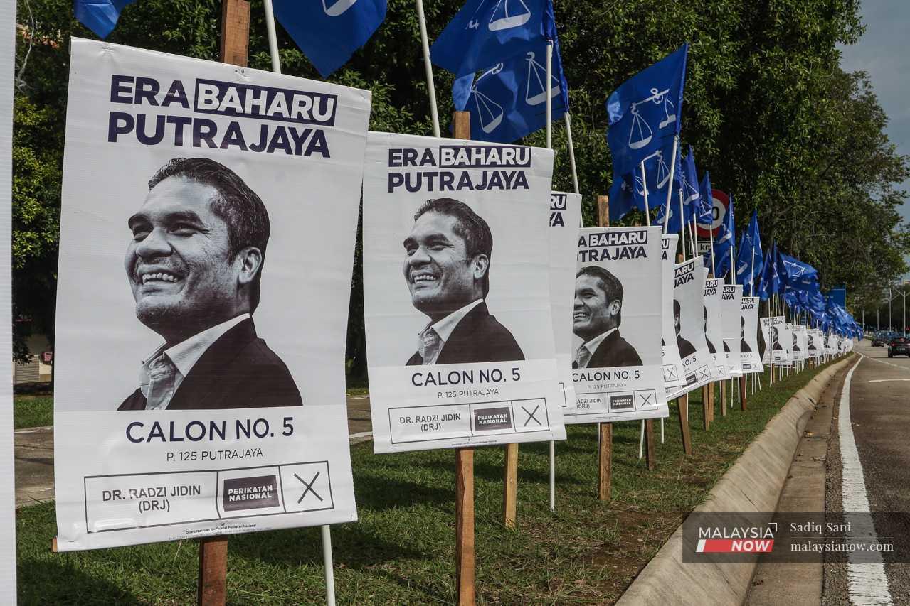 Posters featuring Perikatan Nasional's candidate, Education Minister Radzi Jidin, line a road in Putrajaya. 