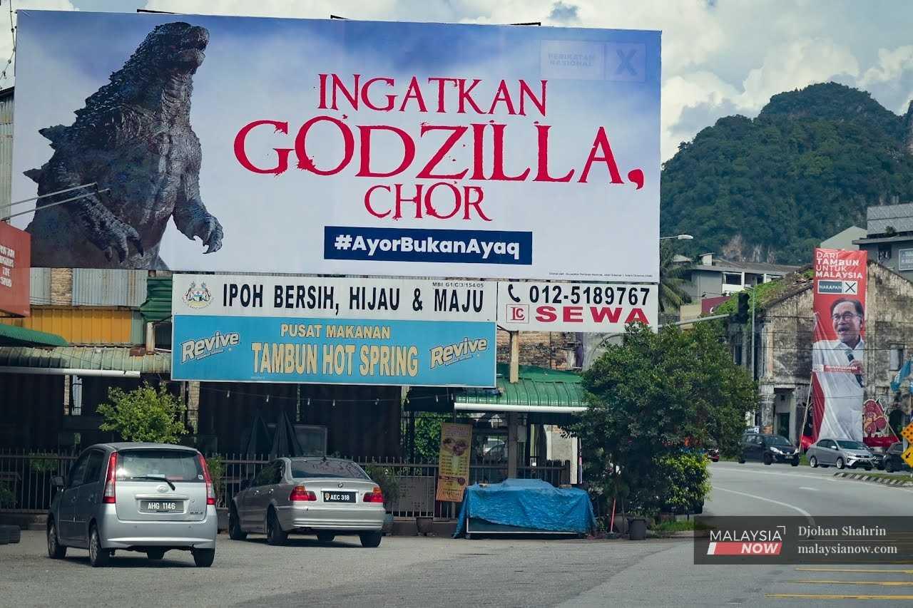 Sebuah papan tanda (kiri) yang dinaikkan calon Perikatan Nasional Ahmad Faizal Azumu seakan menyindir poster calon Pakatan Harapan Anwar Ibrahim menjelang Pilihan Raya Umum ke-15 pada 19 November.