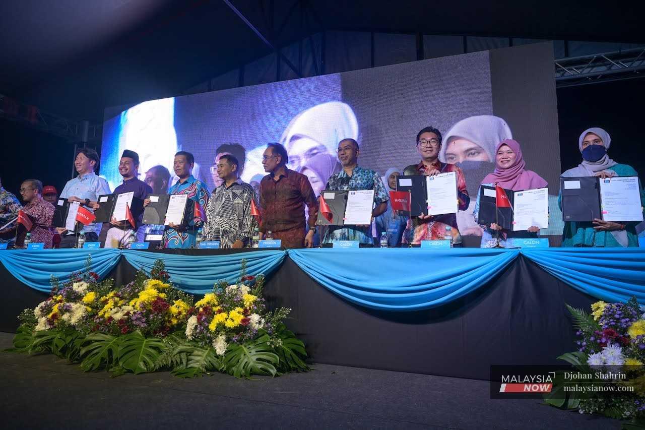 PKR candidates stand with their president Anwar Ibrahim during the party's announcement of its contestants for the upcoming general election in Selangor on Oct 28. Candidates from PKR have declared their assets in the run-up to the polls.