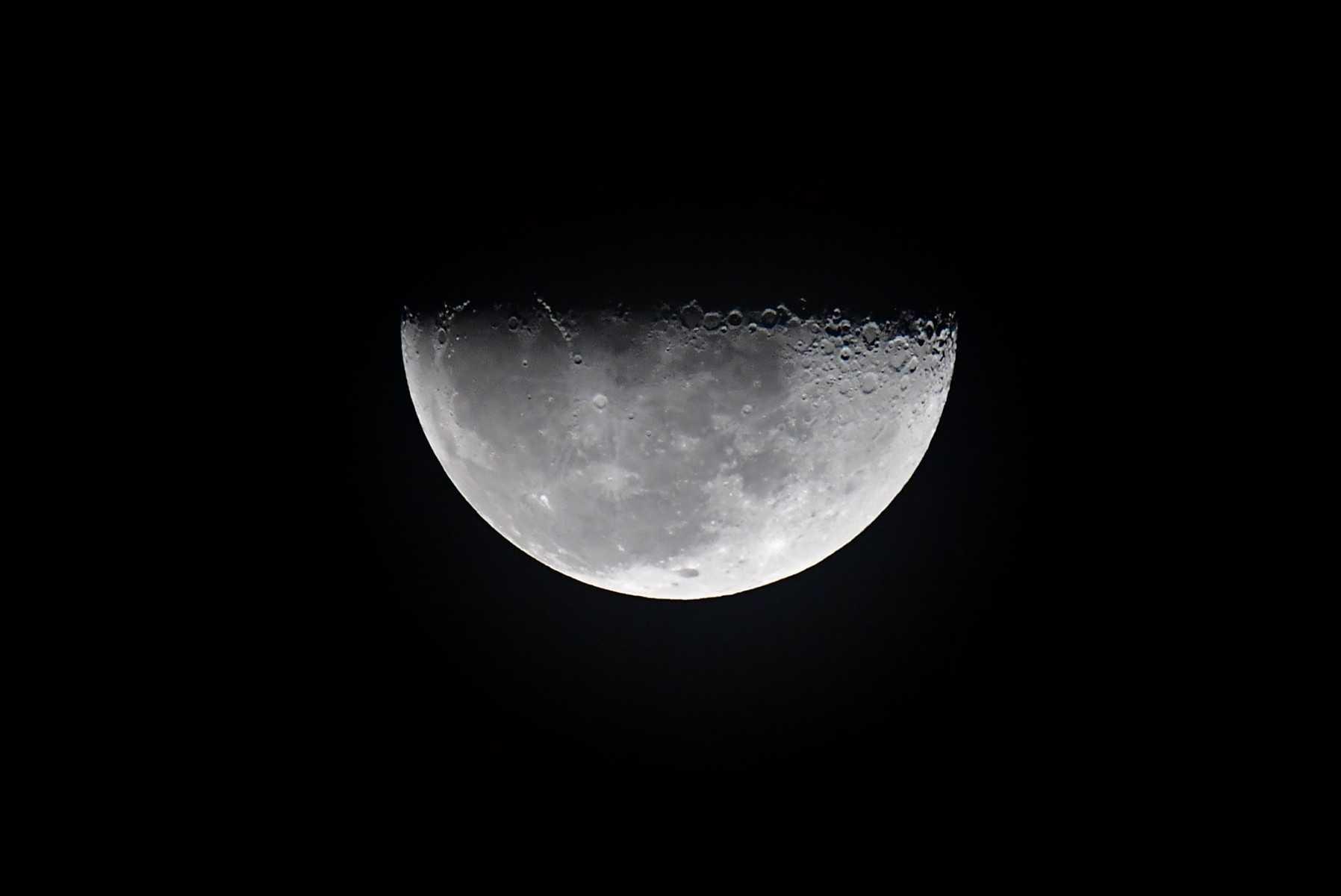 A half moon rises on Nov 16. Photo: AFP 