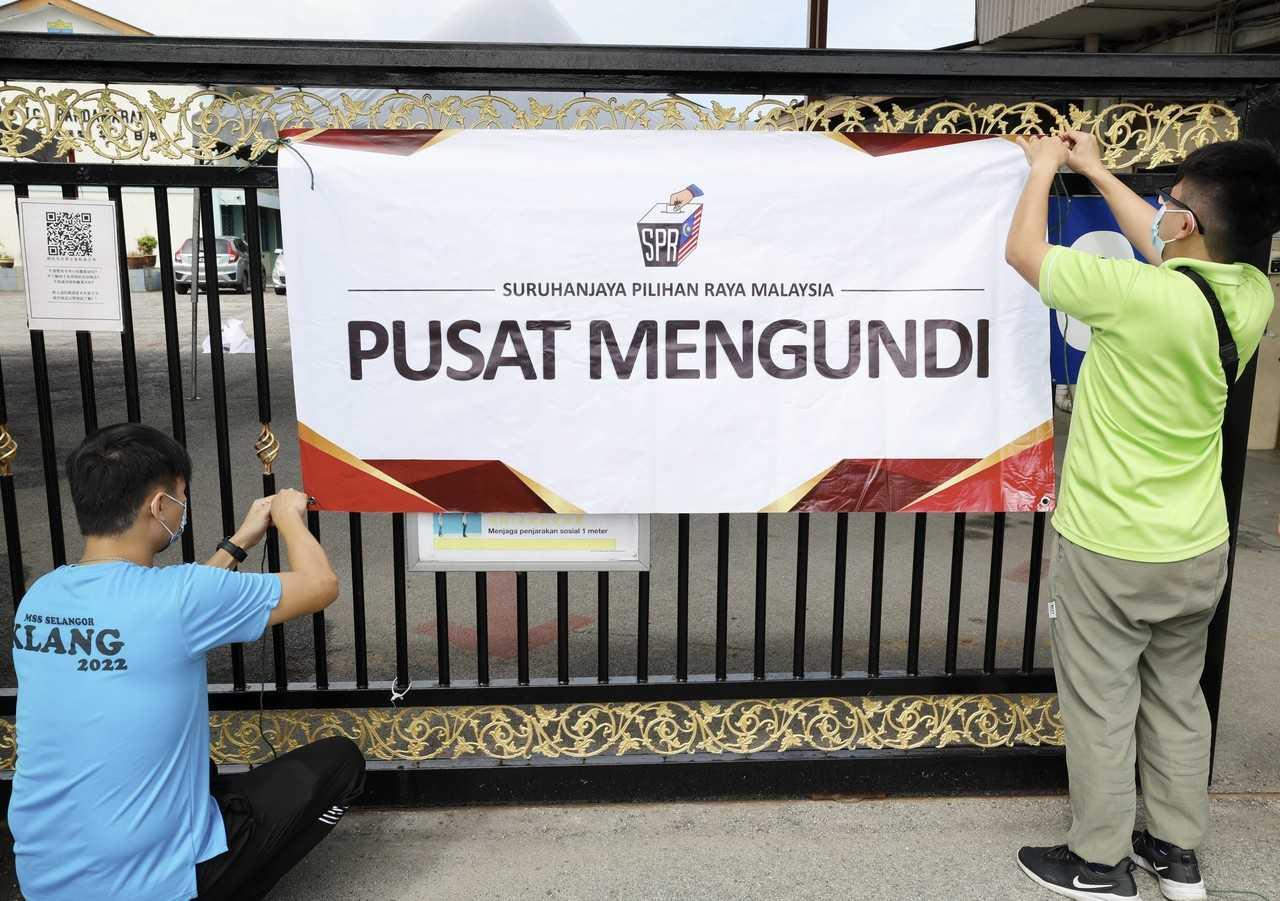 Election Commission workers hang a sign on the gate of a school to be used as a polling centre in Klang, ahead of the election tomorrow. Photo: Bernama