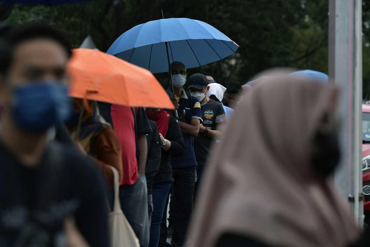 People queue in the rain to vote at the SK Seksyen 17 polling centre in Shah Alam today. Photo: Bernama