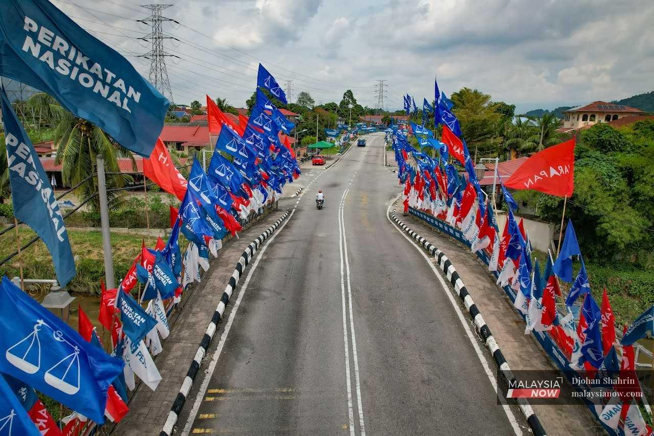 Party flags line either side of a bridge in the Kampung Manjoi enclave in Tambun, Perak.