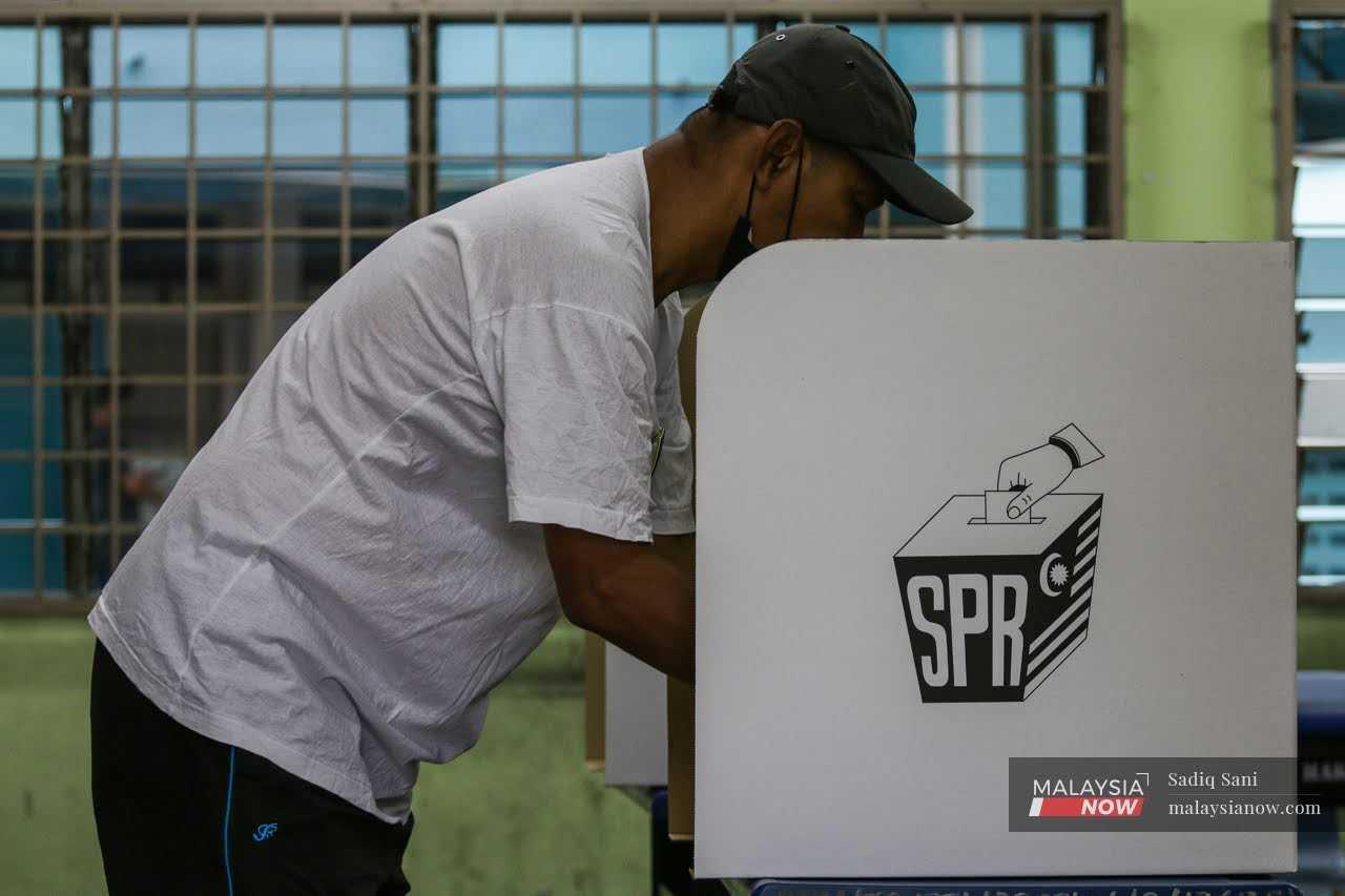 A man casts his vote at the SJKC Selayang Baru polling centre in Selayang today.