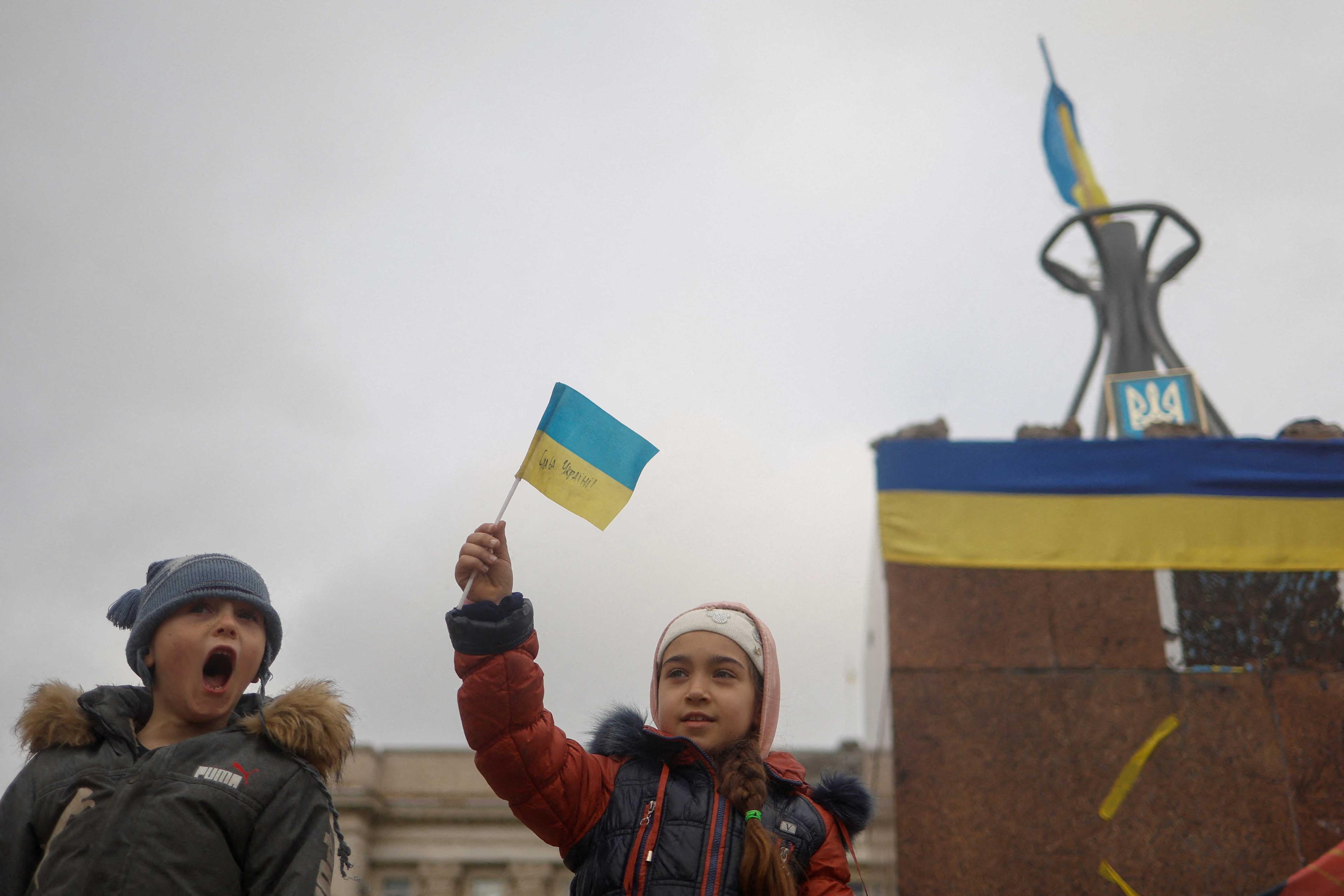 Children celebrate after Russia's retreat from Kherson, in central Kherson, Ukraine Nov 13. Photo: Reuters