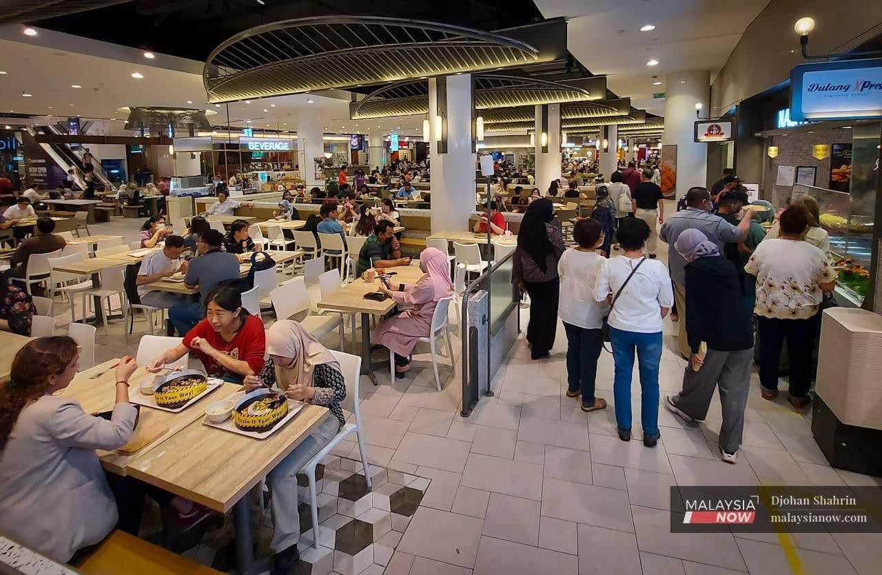 Customers mill about at a food court in a mall in Bukit Bintang, Kuala Lumpur. 