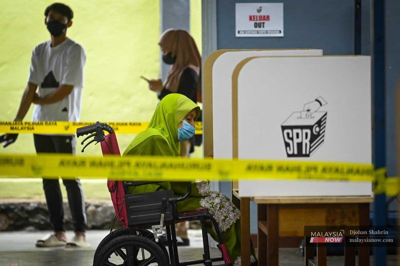Seorang pengundi memangkah kertas undi pada Pilihan Raya Umum ke-15 semalam.