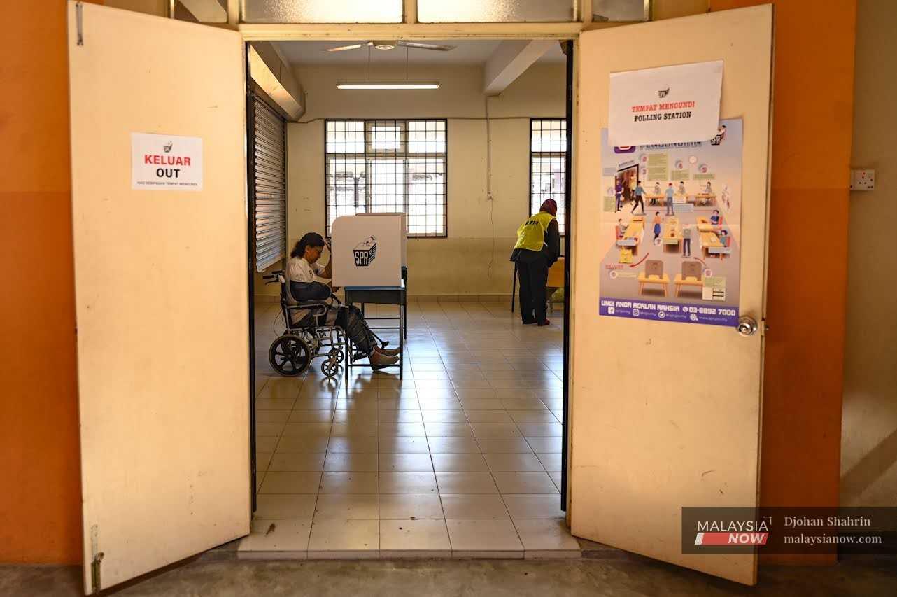 A voter casts her ballot at a polling centre in Kampung Baru, Kuala Lumpur, on Nov 19.