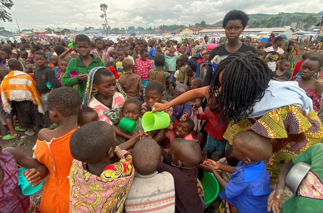 Internally displaced children wash their hands as they wait to receive porridge from volunteers in Munigi camp near Goma, in the North Kivu province of the Democratic Republic of Congo, Nov 18. Photo: Reuters