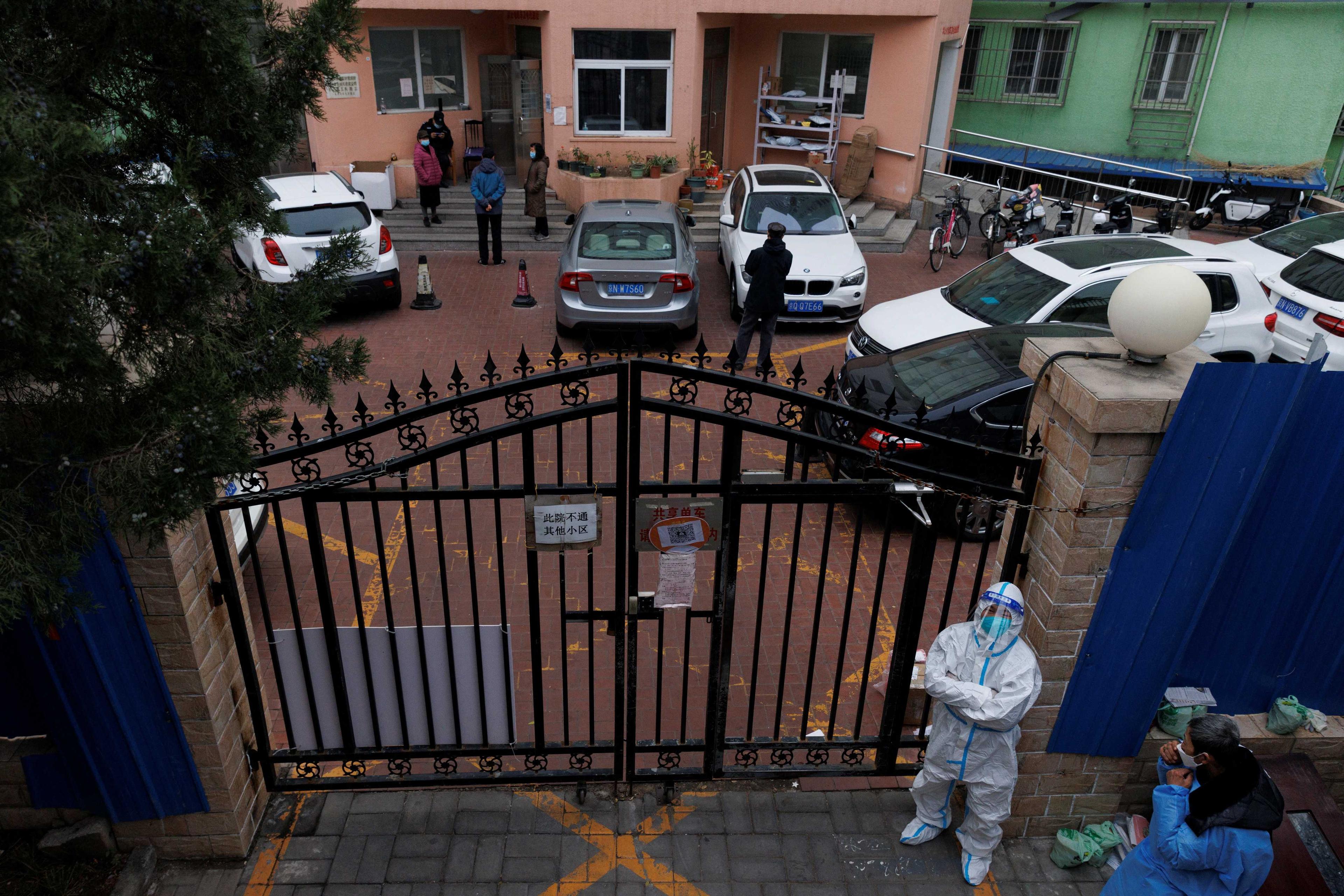 A pandemic prevention worker in a protective suit keeps watch at at residential compound after it was locked down as outbreaks of Covid-19 continue in Beijing, Nov 18. Photo: Reuters