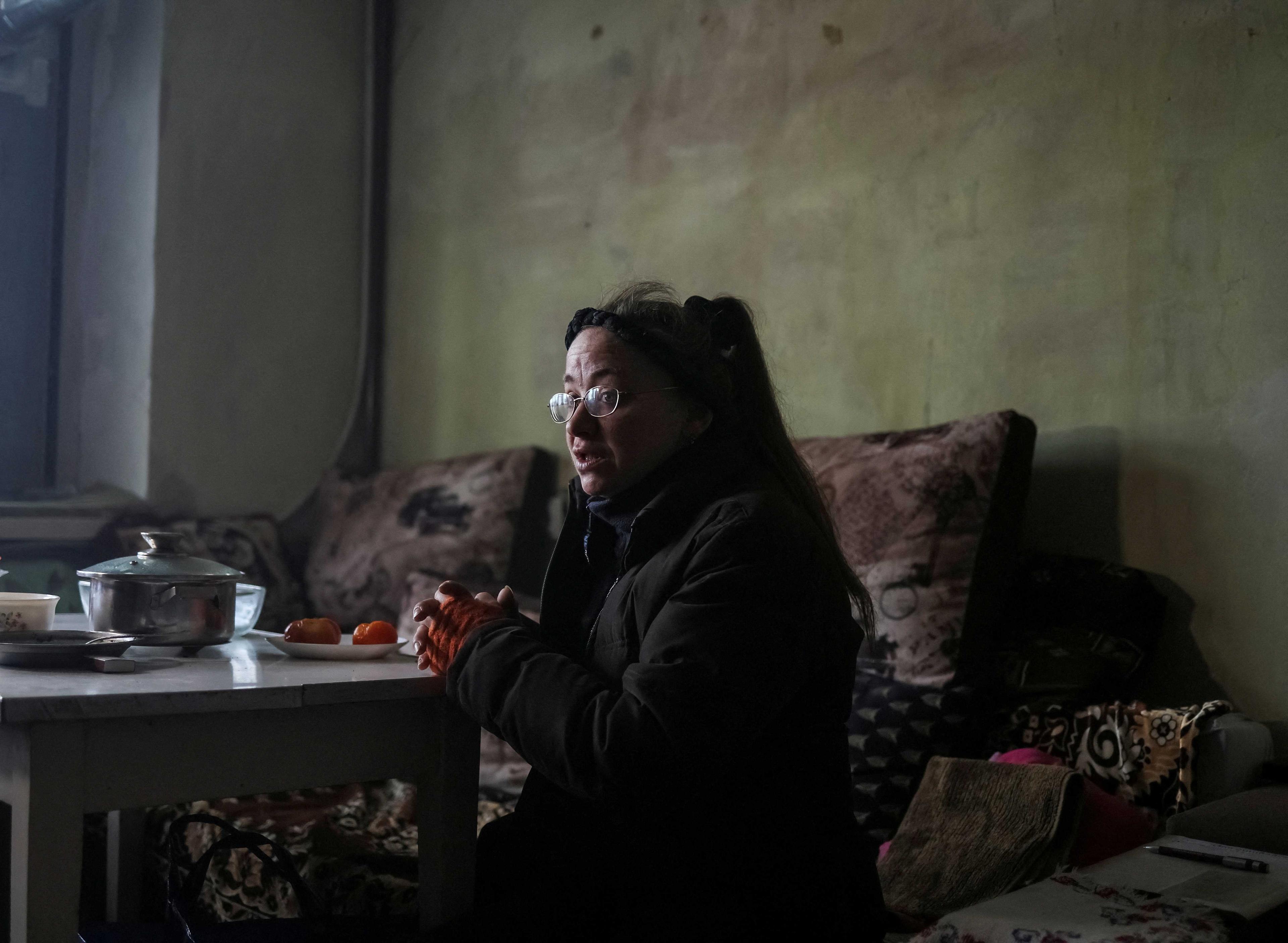 A local resident is seen in her flat, which has no electricity, heating and water, on the fifth floor of an apartment building destroyed by a Russian military strike in the Ukrainian village of Horenka, which was heavily damaged by fighting in the early days of the Russian invasion, Nov 19. Photo: Reuters