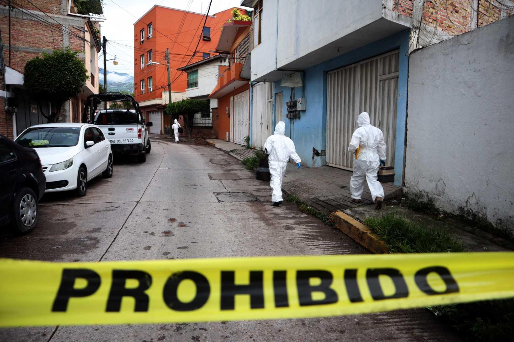 Police investigators in forensic suits inspect the area in Chilpancingo, state of Guerrero, Mexico, on Aug 22. Photo: AFP 