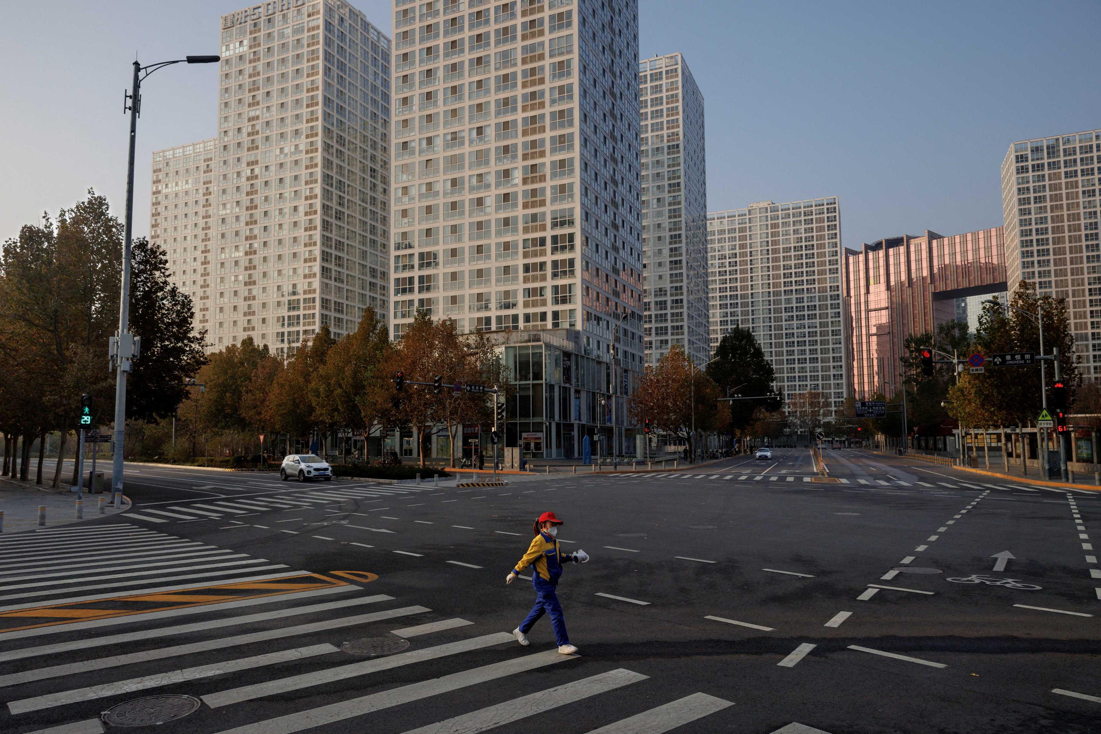 A woman crosses a street during morning rush hour after work-from-home orders kept the Central Business District largely empty as outbreaks of Covid-19 continue in Beijing, China, Nov 23. Photo: Reuters