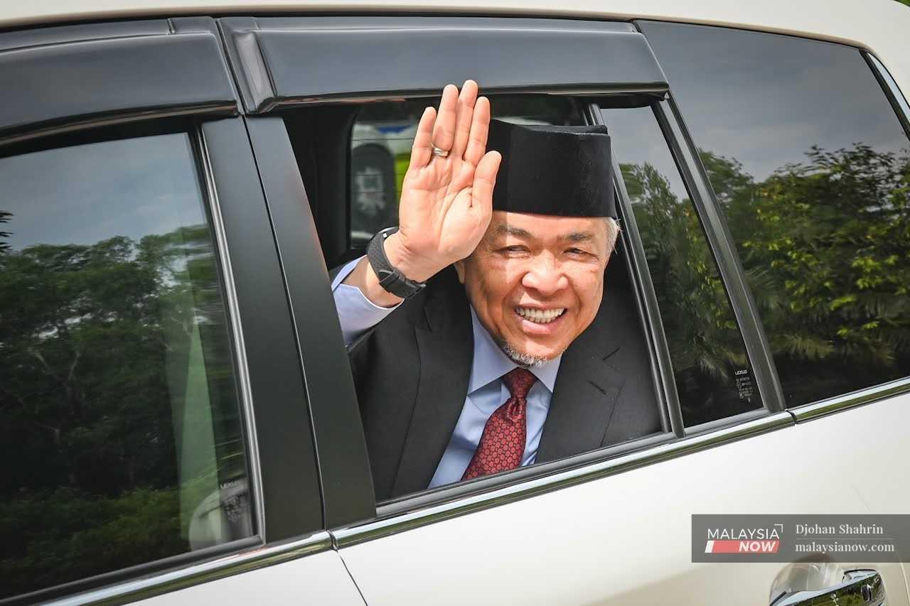 Barisan Nasional chairman Ahmad Zahid Hamidi waves as he leaves the palace after an audience with the Agong in Kuala Lumpur today. 
