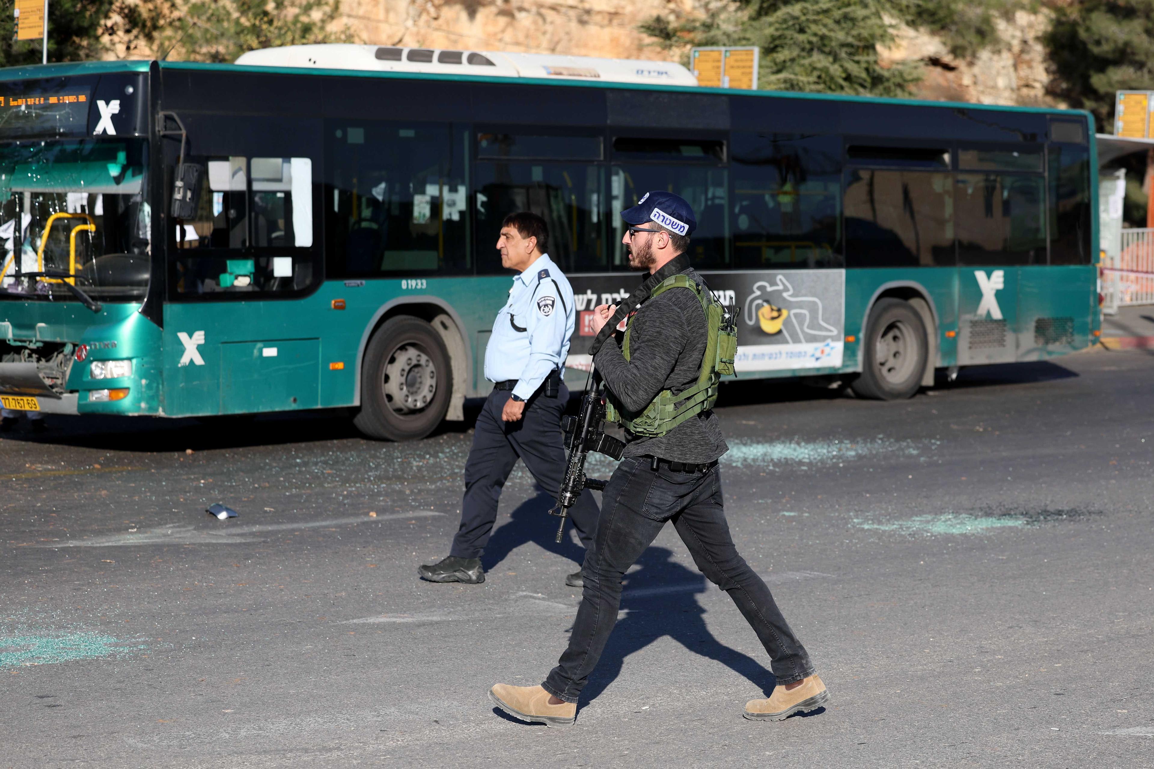 Israeli security forces walk at the scene of an explosion at a bus stop in Jerusalem on Nov 23. Photo: AFP 