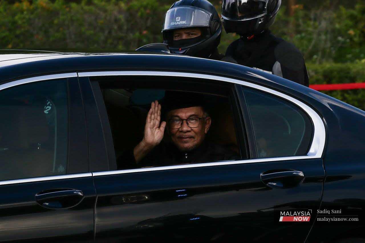 Pakatan Harapan chairman Anwar Ibrahim waves as he arrives to be sworn in as prime minister at Istana Negara in Kuala Lumpur.
