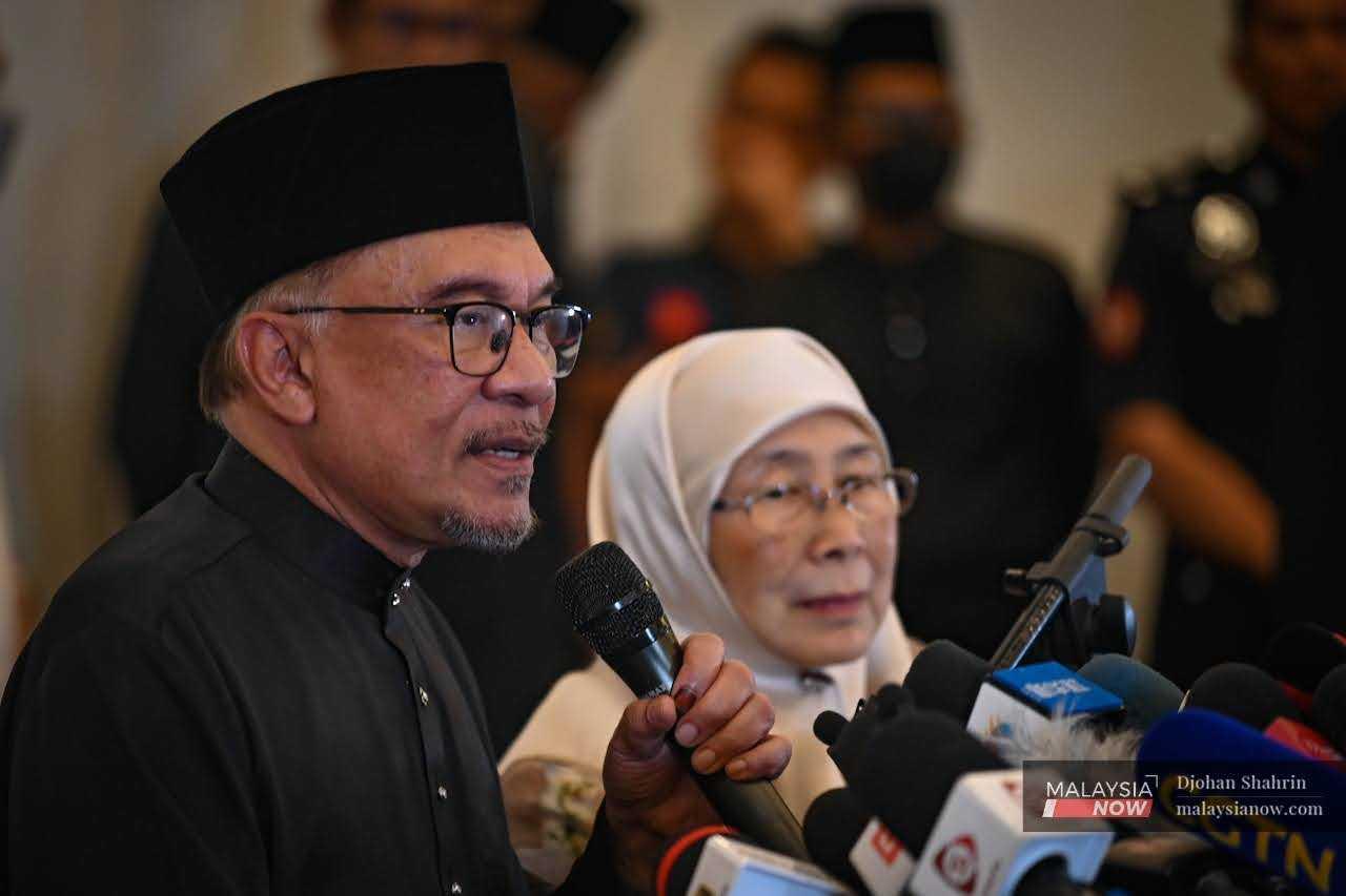 Anwar Ibrahim, flanked by his wife, Dr Wan Azizah Wan Ismail, speaks at his first press conference as prime minister in Sungai Long, Kajang. 
