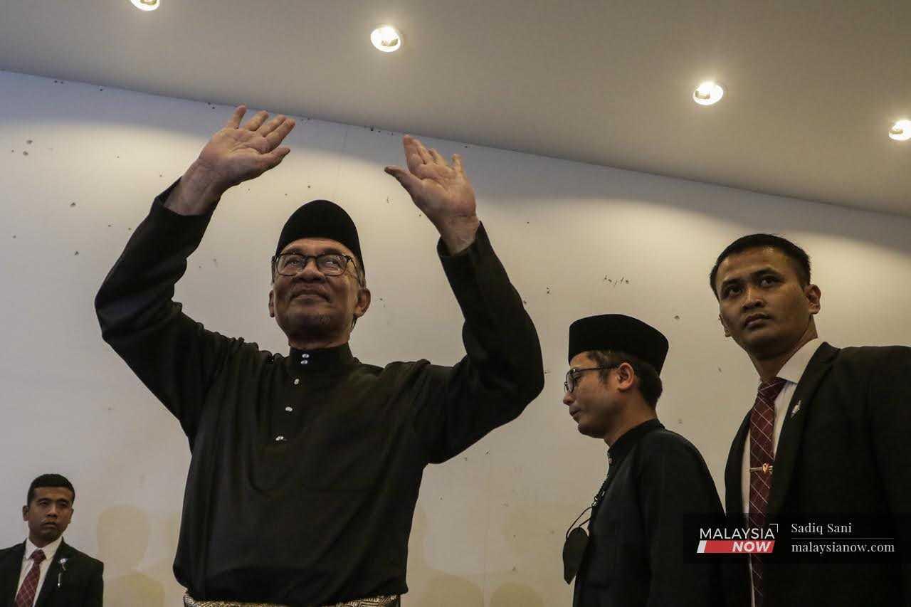 Anwar Ibrahim melambaikan tangan kepada penyokongnya pada sidang media pertama sebagai perdana menteri ke-10 semalam.