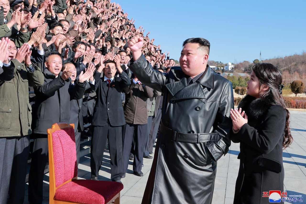 North Korean leader Kim Jong Un and his daughter attend a photo session with those involved in the test-fire of the country's new Hwasong-17 intercontinental ballistic missile in this undated photo released on Nov 27 by the Korean Central News Agency. Photo: Reuters