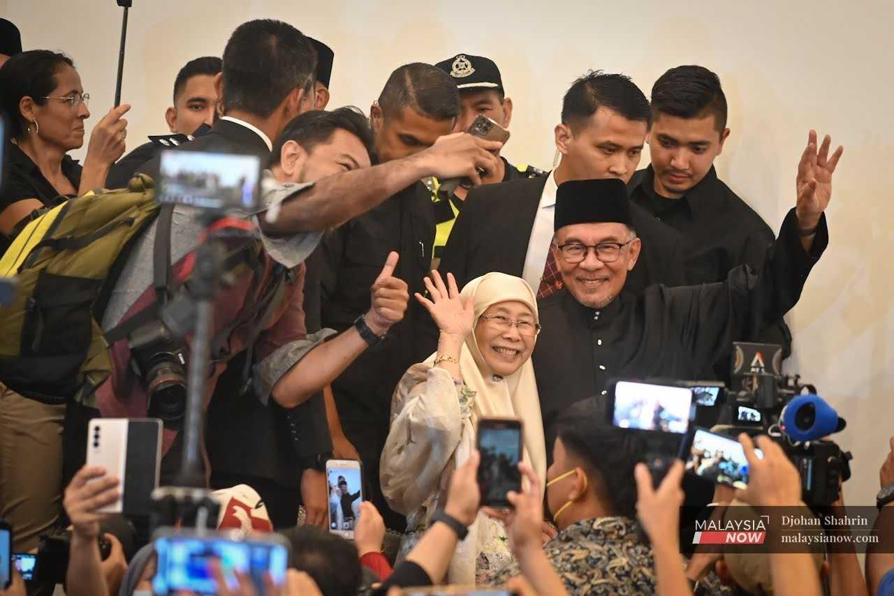Beliau dan isteri, Dr Wan Azizah Wan Ismail, melambai kepada pemberita di akhir sidang media.