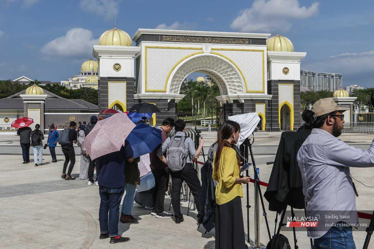Others gather outside the palace as the Agong meets with the Malay rulers in order to break the days-long impasse. 